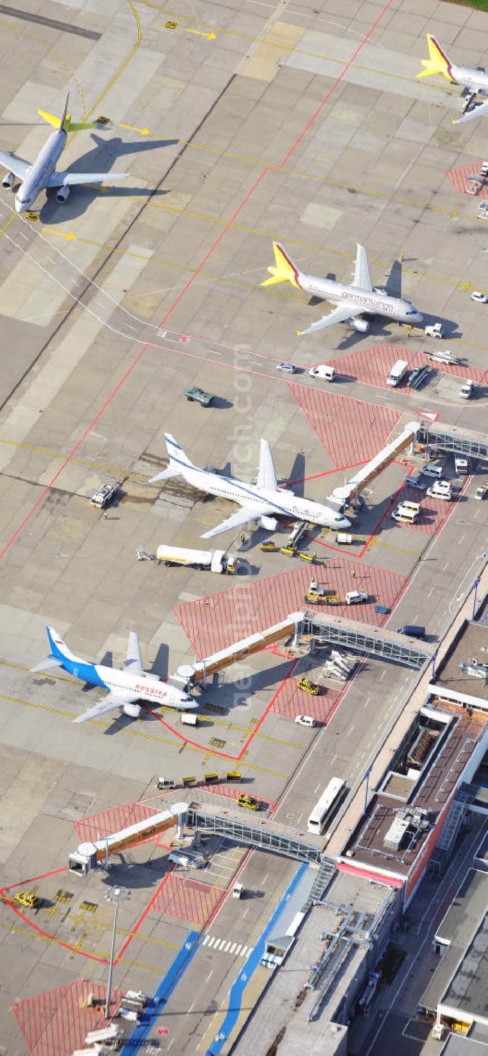 Berlin Schönefeld from above - Das alte Abfertigungs- Terminal am Flughafen Berlin - Schönefeld mit dem Vorfeld und den Gates / Passagierbrücken zu den Flugzeugen. Im Bild eine Maschine der israelischen Fluggesellschaft EL AL , welche unter dem Schutz eines Schützenpanzers des Bundesgrenzschutz abgefertigt wird. Parking, passenger terminal and movement area fo the Schönefeld Airport.