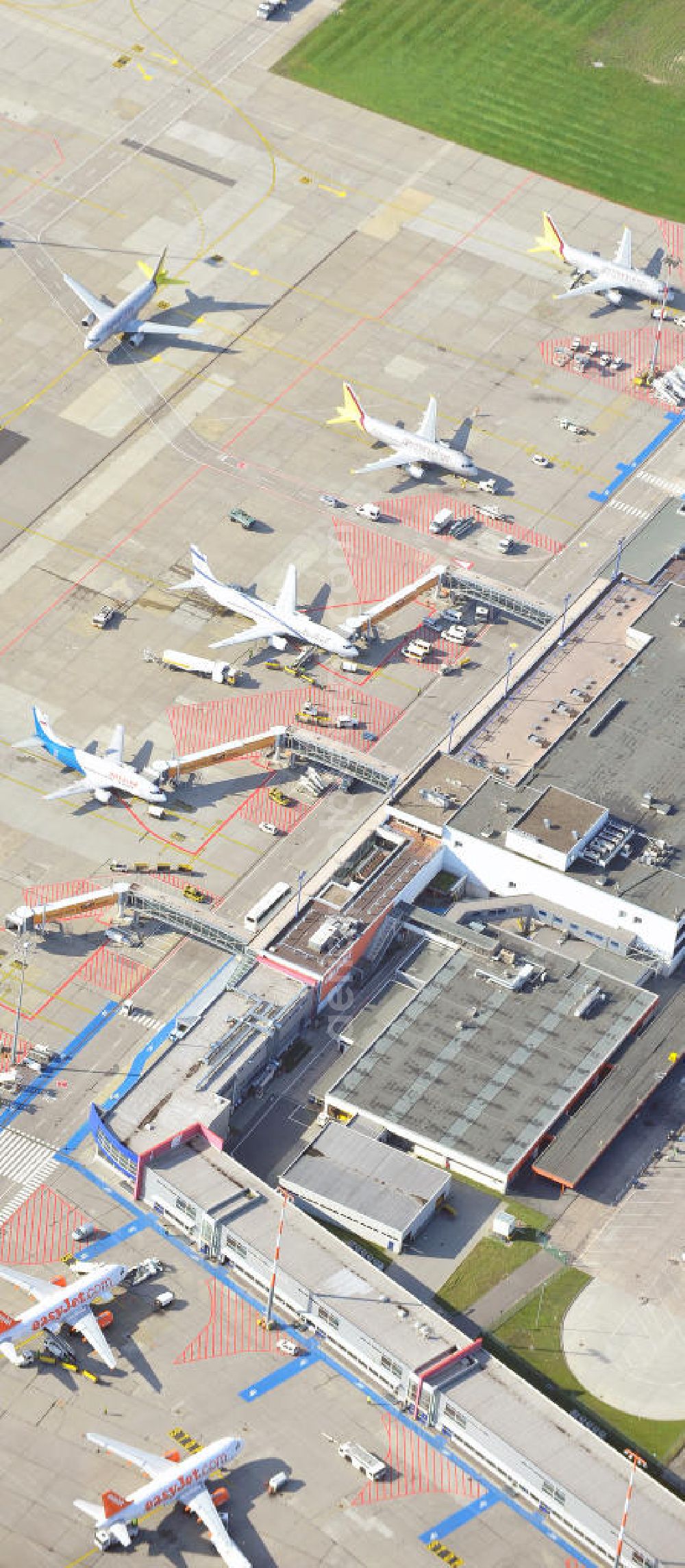 Berlin Schönefeld from the bird's eye view: Das alte Abfertigungs- Terminal am Flughafen Berlin - Schönefeld mit dem Vorfeld und den Gates / Passagierbrücken zu den Flugzeugen. Im Bild eine Maschine der israelischen Fluggesellschaft EL AL , welche unter dem Schutz eines Schützenpanzers des Bundesgrenzschutz abgefertigt wird. Parking, passenger terminal and movement area fo the Schönefeld Airport.