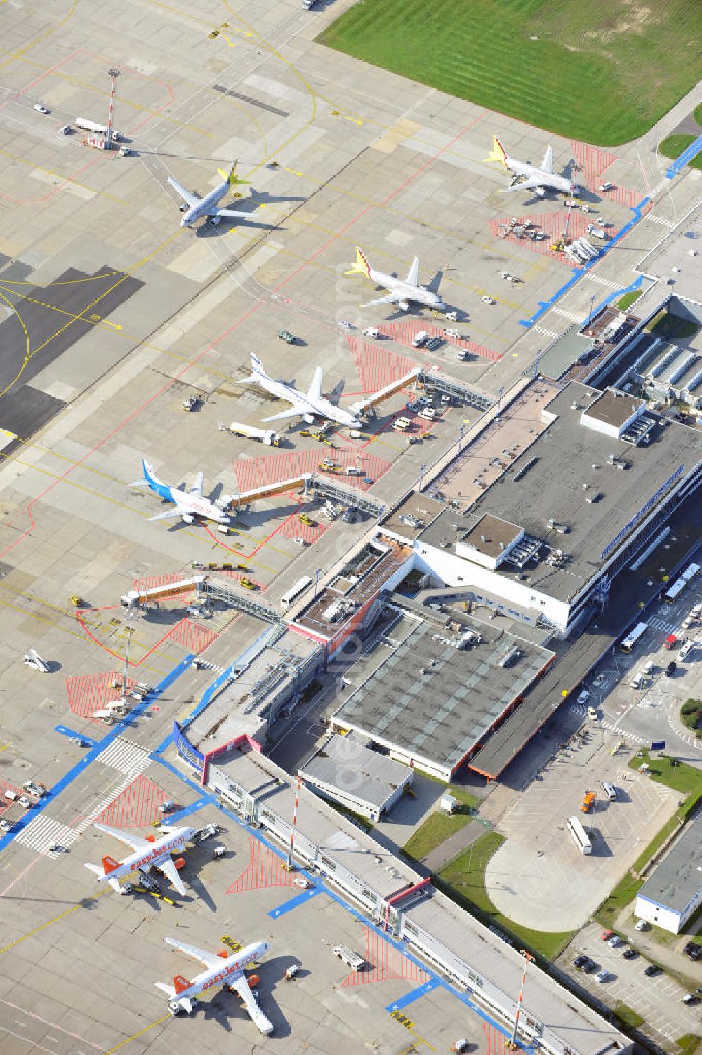 Aerial image Berlin Schönefeld - Das alte Abfertigungs- Terminal am Flughafen Berlin - Schönefeld mit dem Vorfeld und den Gates / Passagierbrücken zu den Flugzeugen. Im Bild eine Maschine der israelischen Fluggesellschaft EL AL , welche unter dem Schutz eines Schützenpanzers des Bundesgrenzschutz abgefertigt wird. Parking, passenger terminal and movement area fo the Schönefeld Airport.