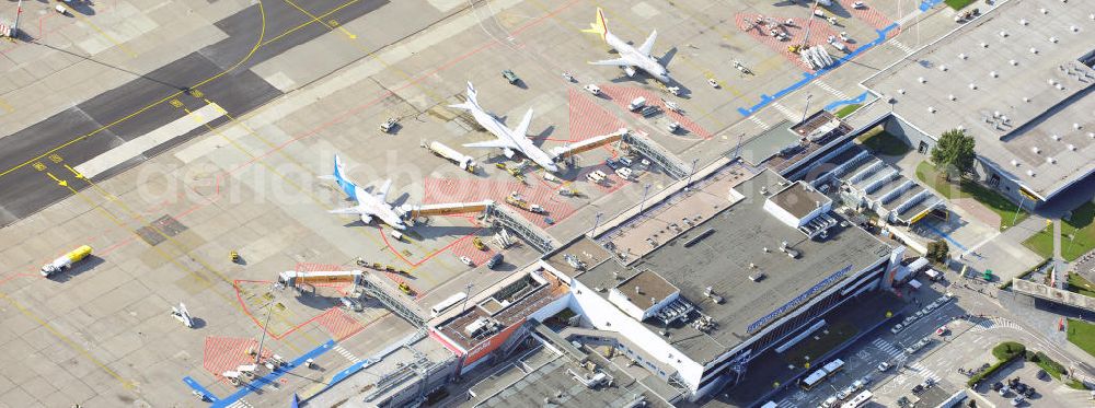 Aerial photograph Berlin Schönefeld - Das alte Abfertigungs- Terminal am Flughafen Berlin - Schönefeld mit dem Vorfeld und den Gates / Passagierbrücken zu den Flugzeugen. Im Bild eine Maschine der israelischen Fluggesellschaft EL AL , welche unter dem Schutz eines Schützenpanzers des Bundesgrenzschutz abgefertigt wird. Parking, passenger terminal and movement area fo the Schönefeld Airport.