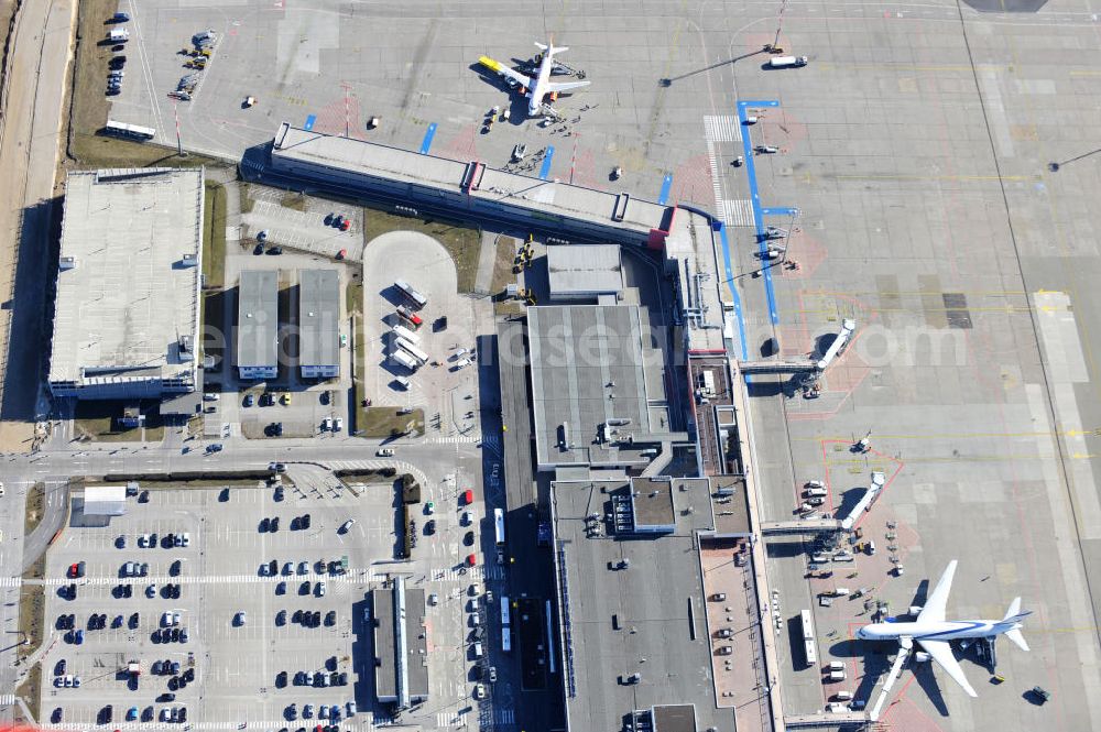 Aerial photograph Schönefeld - Blick auf die temporär verwaiste Abfertigungshalle am Flughafen Berlin-Schönefeld. Wenn der Flughaffen BBI in absehbarer Zeit in Betrieb gehen wird, dann können solche Bilder für das zum Teil noch aus INTERFLUG-Zeiten stammende Terminal zum Dauerzustand werden. Terminals at the airport Berlin-Schoenefeld.