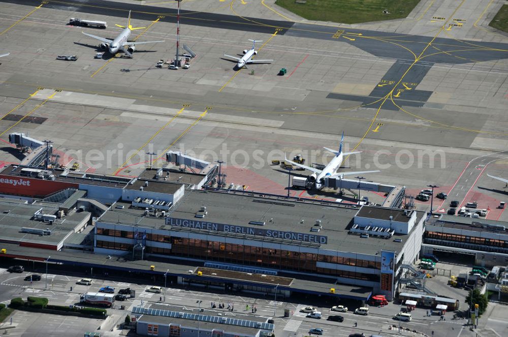 Schönefeld from the bird's eye view: Blick auf die temporär verwaiste Abfertigungshalle am Flughafen Berlin-Schönefeld. Wenn der Flughaffen BBI in absehbarer Zeit in Betrieb gehen wird, dann können solche Bilder für das zum Teil noch aus INTERFLUG-Zeiten stammende Terminal zum Dauerzustand werden. Terminals at the airport Berlin-Schoenefeld.