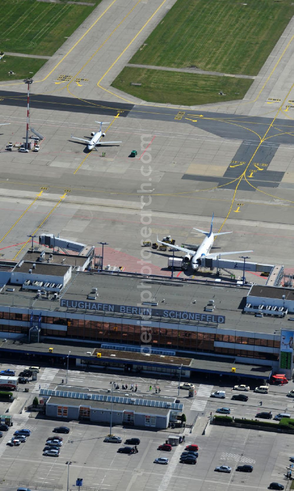 Aerial image Schönefeld - Blick auf die temporär verwaiste Abfertigungshalle am Flughafen Berlin-Schönefeld. Wenn der Flughaffen BBI in absehbarer Zeit in Betrieb gehen wird, dann können solche Bilder für das zum Teil noch aus INTERFLUG-Zeiten stammende Terminal zum Dauerzustand werden. Terminals at the airport Berlin-Schoenefeld.