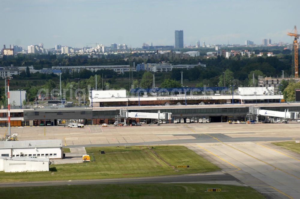 SCHÖNEFELD from the bird's eye view: Blick auf die temporär verwaiste Abfertigungshalle am Flughafen Berlin-Schönefeld. Wenn der Flughaffen BBI in absehbarer Zeit in Betrieb gehen wird, dann können solche Bilder für das zum Teil noch aus INTERFLUG-Zeiten stammende Terminal zum Dauerzustand werden.