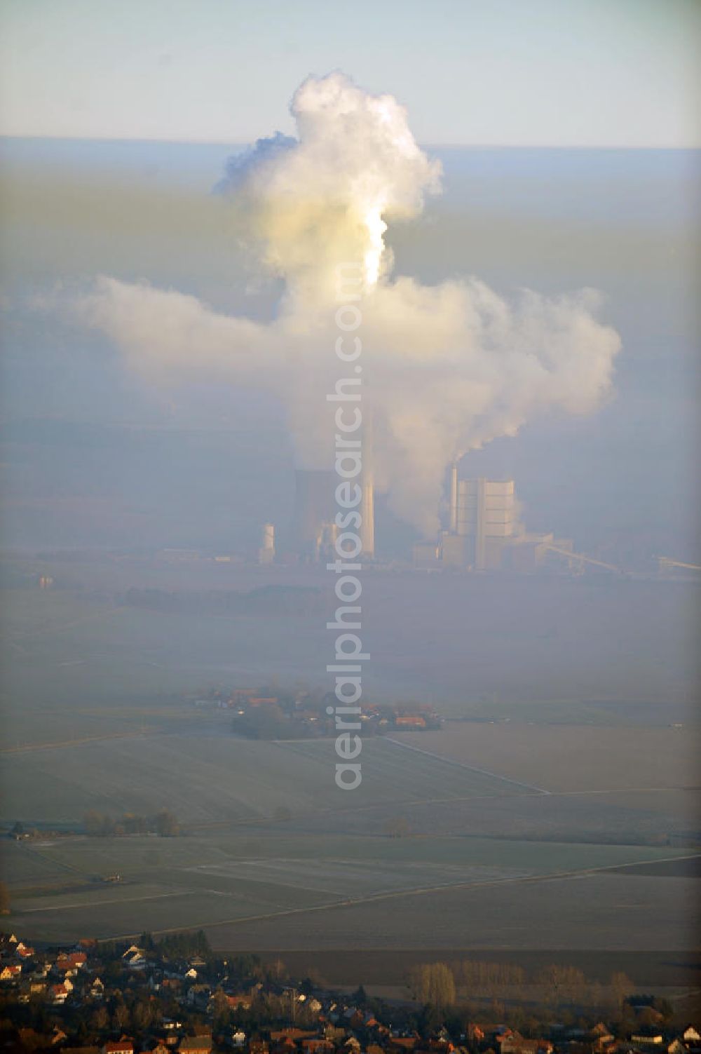 Schöningen from above - Weithin sichtbare Abgas- und Rauchwolken der Türme des Kraftwerk Buschhaus , einem Braunkohlekraftwerk im Helmstedter Revier, nahe der Ortschaft Schöningen. Das Kraftwerk der E.ON Kraftwerke GmbH wurde Ende der 1970er-Jahre geplant. Der neue Kraftwerksbau schuf zusätzliche Arbeitsplätze im Kohlebergbau und in der Verstromung. Das Kraftwerk sollte mit der schwefelhaltigen Salzkohle der Umgebung betrieben werden. Für die benötigte Menge wurde eigens ein neuer Tagebau, der Tagebau Schöningen, aufgefahren. Das Kraftwerk verfügt über einen 307 Meter hohen Schornstein, der der höchste in Betrieb befindliche Industrieschornstein in Deutschland ist. Highly visible exhaust and smoke of the towers of the power plant bush house, a brown coal power plant in the Helmstedt area, near the village of Schöningen.