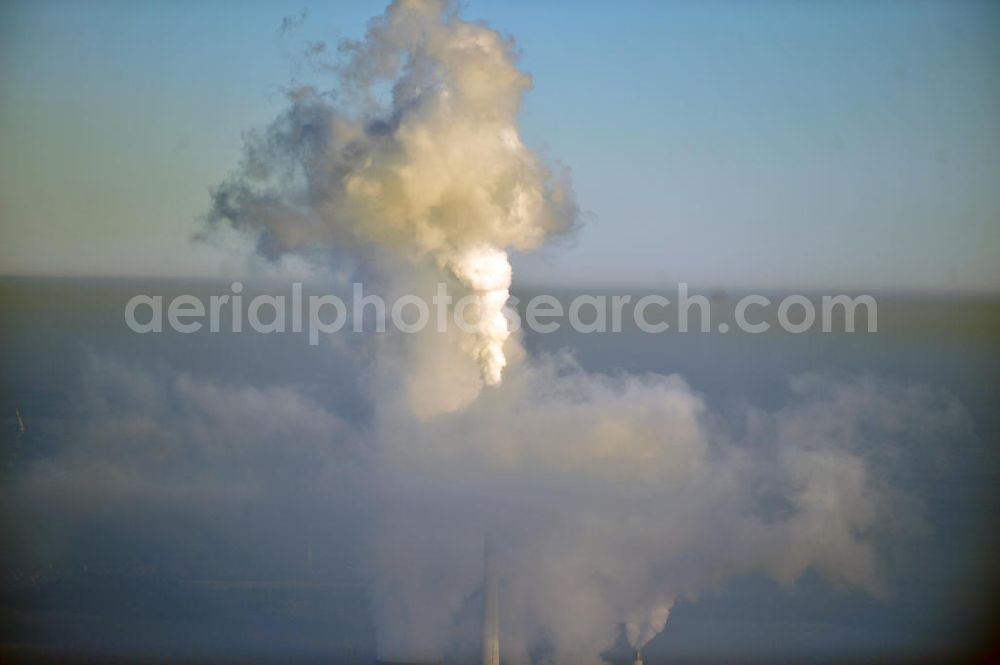 Aerial image Schöningen - Weithin sichtbare Abgas- und Rauchwolken der Türme des Kraftwerk Buschhaus , einem Braunkohlekraftwerk im Helmstedter Revier, nahe der Ortschaft Schöningen. Das Kraftwerk der E.ON Kraftwerke GmbH wurde Ende der 1970er-Jahre geplant. Der neue Kraftwerksbau schuf zusätzliche Arbeitsplätze im Kohlebergbau und in der Verstromung. Das Kraftwerk sollte mit der schwefelhaltigen Salzkohle der Umgebung betrieben werden. Für die benötigte Menge wurde eigens ein neuer Tagebau, der Tagebau Schöningen, aufgefahren. Das Kraftwerk verfügt über einen 307 Meter hohen Schornstein, der der höchste in Betrieb befindliche Industrieschornstein in Deutschland ist. Highly visible exhaust and smoke of the towers of the power plant bush house, a brown coal power plant in the Helmstedt area, near the village of Schöningen.