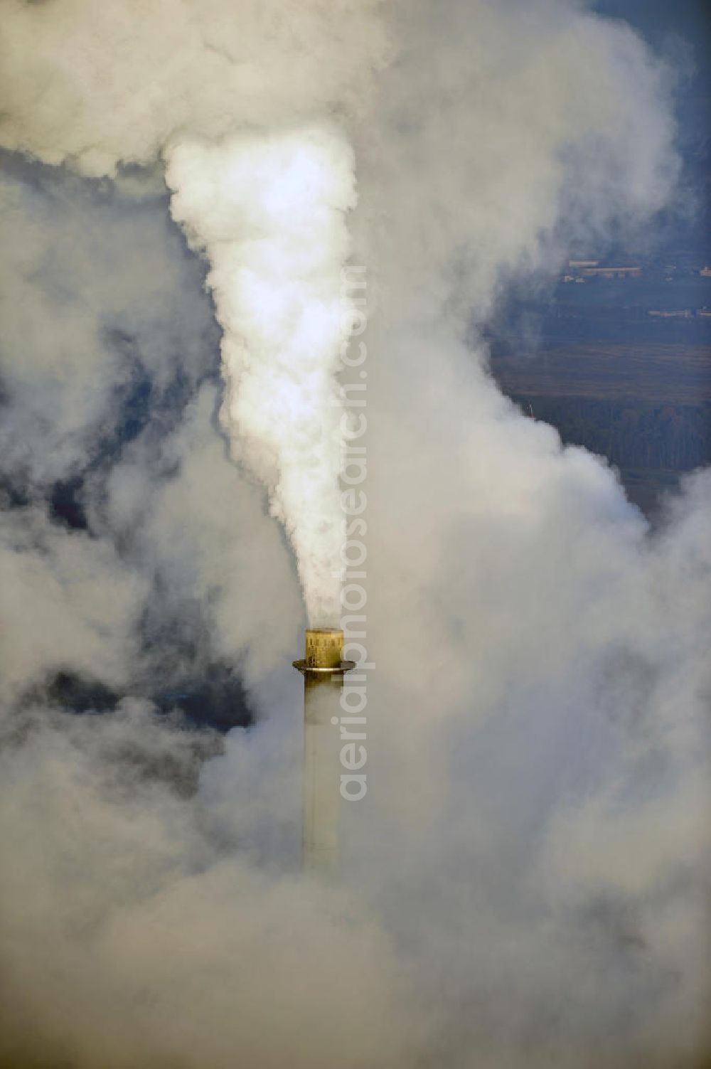 Aerial image Schöningen - Weithin sichtbare Abgas- und Rauchwolken der Türme des Kraftwerk Buschhaus , einem Braunkohlekraftwerk im Helmstedter Revier, nahe der Ortschaft Schöningen. Das Kraftwerk der E.ON Kraftwerke GmbH wurde Ende der 1970er-Jahre geplant. Der neue Kraftwerksbau schuf zusätzliche Arbeitsplätze im Kohlebergbau und in der Verstromung. Das Kraftwerk sollte mit der schwefelhaltigen Salzkohle der Umgebung betrieben werden. Für die benötigte Menge wurde eigens ein neuer Tagebau, der Tagebau Schöningen, aufgefahren. Das Kraftwerk verfügt über einen 307 Meter hohen Schornstein, der der höchste in Betrieb befindliche Industrieschornstein in Deutschland ist. Highly visible exhaust and smoke of the towers of the power plant bush house, a brown coal power plant in the Helmstedt area, near the village of Schöningen.