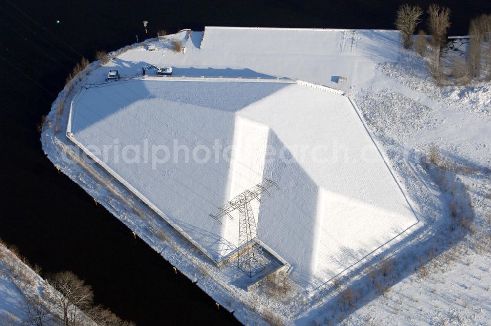 Berlin from the bird's eye view: Blick auf die winterlich mit Schnee bedeckte 30 Meter hohe Abraumhalde der ehemaligen VEB Kali Chemie. Hier lagern hochgiftige Rest von Lacke und Farben mit hohen Dosen Cyanid und Arsen. Die Halde befindet sich auf den s.g. Zickenwinkel, an der Mündung des Britzer Zweigkanal in die Spree.