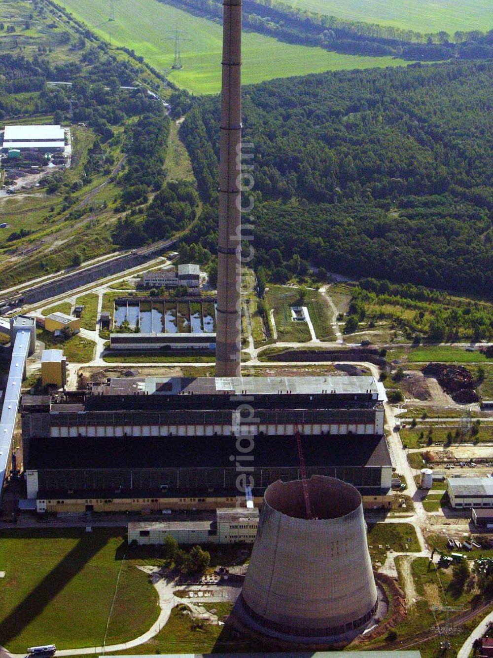 Aerial photograph Neukieritzsch - 27.08.2005 Neukieritzsch; Durch die nach 1990 gültigen Umweltgesetze entschieden die Eigentümer, dass eine Nachrüstung mit moderner Umwelttechnik aus technischen wie wirtschaftlichen Gründen nicht realisierbar ist. Deshalb erfolgte mit der Inbetriebnahme der beiden Neubau-Blöcke die schrittweise Stilllegung und der Rückbau des Altkraftwerkes Lippendorf. Der erste Kühlturm wurde am 6. Dezember 1997 gesprengt, der zweite wurde 2005 mittels hydraulischer Abbruchzange rückgebaut. Am 27. August 2005 wurde der Schornstein gesprengt, am 5. September 2005 folgte das Kesselhaus.