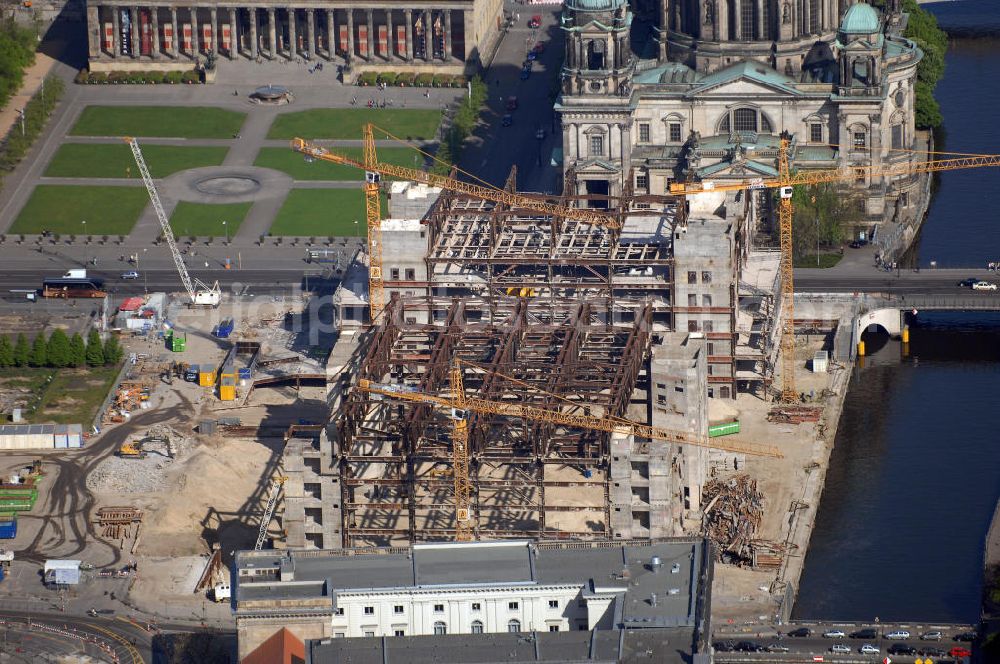 Berlin from the bird's eye view: Blick auf den Abriss des Palast der Republik in Mitte.Der Rückbau des Palastes der Republik verschob sich immer wieder. Am 19. Januar 2006 beschloss der Deutsche Bundestag, Anträgen der Grünen und der Linkspartei zur Verschiebung des Abrisses bzw. zur Erhaltung des Bauwerks nicht stattzugeben.Nach Terminen im Frühjahr 2005 und im Oktober 2005 wird das Gebäude seit Februar 2006 langsam mithilfe von fünf Kränen zurückgebaut. Von einer Sprengung des Gebäudes wurde abgesehen, weil Beschädigungen umliegender Gebäude durch den Auftrieb der Bodenwanne und das dadurch bedingte Absinken des Grundwasserspiegels befürchtet wurden. Stattdessen wird das abgetragene Material gemessen und im gleichen Maß dann mit Wasser versetzter Sand in die Bodenwanne geleitet.Die Abrissarbeiten sollten ursprünglich Mitte 2007 abgeschlossen sein. Nachdem im Laufe der Arbeiten an mehreren Stellen neues Asbest gefunden wurde und sich der Abriss dadurch stark verlangsamte, wird mit Ende 2008 als frühestes Ende kalkuliert. Die Zusatzkosten in Höhe von bislang 9,9 Mio. Euro muss der Bund übernehmen.Nach der vollständigen Abtragung soll vorübergehend eine Grünfläche über der verbleibenden Bodenwanne entstehen.