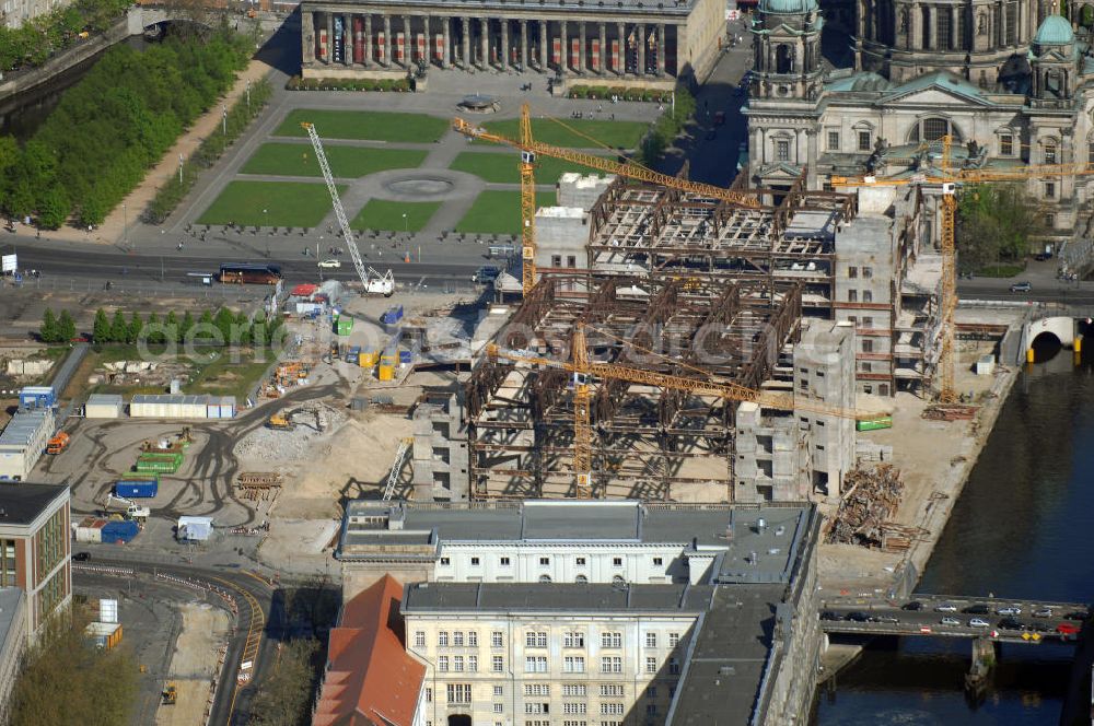 Berlin from the bird's eye view: Blick auf den Abriss des Palast der Republik in Mitte.Der Rückbau des Palastes der Republik verschob sich immer wieder. Am 19. Januar 2006 beschloss der Deutsche Bundestag, Anträgen der Grünen und der Linkspartei zur Verschiebung des Abrisses bzw. zur Erhaltung des Bauwerks nicht stattzugeben.Nach Terminen im Frühjahr 2005 und im Oktober 2005 wird das Gebäude seit Februar 2006 langsam mithilfe von fünf Kränen zurückgebaut. Von einer Sprengung des Gebäudes wurde abgesehen, weil Beschädigungen umliegender Gebäude durch den Auftrieb der Bodenwanne und das dadurch bedingte Absinken des Grundwasserspiegels befürchtet wurden. Stattdessen wird das abgetragene Material gemessen und im gleichen Maß dann mit Wasser versetzter Sand in die Bodenwanne geleitet.Die Abrissarbeiten sollten ursprünglich Mitte 2007 abgeschlossen sein. Nachdem im Laufe der Arbeiten an mehreren Stellen neues Asbest gefunden wurde und sich der Abriss dadurch stark verlangsamte, wird mit Ende 2008 als frühestes Ende kalkuliert. Die Zusatzkosten in Höhe von bislang 9,9 Mio. Euro muss der Bund übernehmen.Nach der vollständigen Abtragung soll vorübergehend eine Grünfläche über der verbleibenden Bodenwanne entstehen.