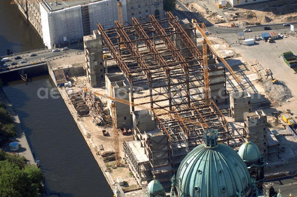 Aerial image Berlin - . Seit Februar 2006 wird der Palast langsam mit Hilfe von fünf Kränen abgerissen. Von einer Sprengung des Gebäudes wurde abgesehen, weil Beschädigungen umliegender Häuser durch den Auftrieb der Bodenwanne und das dadurch bedingte Absinken des Grundwasserspiegels befürchtet wurden. Stattdessen wird das abgetragene Material gemessen und dann im gleichen Maß mit Wasser versetzter Sand in die Bodenwanne geleitet. Die Abrissarbeiten sollten ursprünglich Mitte 2007 abgeschlossen sein. Nachdem im Laufe der Arbeiten an mehreren Stellen neuer Asbest gefunden wurde und sich der Abriss dadurch stark verlangsamte, wird mit Ende 2008 als frühestem Ende kalkuliert. Die Zusatzkosten in Höhe von bislang 9,9 Mio. Euro muss der Bund übernehmen. Nach der vollständigen Abtragung soll vorübergehend eine Grünfläche über der verbleibenden Bodenwanne entstehen.