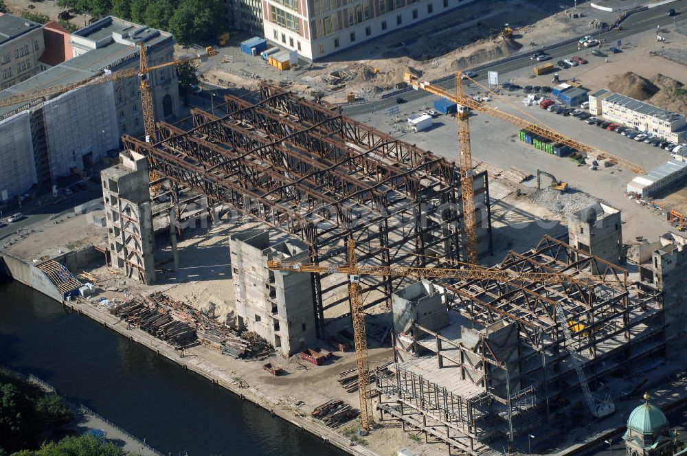 Aerial image Berlin - . Seit Februar 2006 wird der Palast langsam mit Hilfe von fünf Kränen abgerissen. Von einer Sprengung des Gebäudes wurde abgesehen, weil Beschädigungen umliegender Häuser durch den Auftrieb der Bodenwanne und das dadurch bedingte Absinken des Grundwasserspiegels befürchtet wurden. Stattdessen wird das abgetragene Material gemessen und dann im gleichen Maß mit Wasser versetzter Sand in die Bodenwanne geleitet. Die Abrissarbeiten sollten ursprünglich Mitte 2007 abgeschlossen sein. Nachdem im Laufe der Arbeiten an mehreren Stellen neuer Asbest gefunden wurde und sich der Abriss dadurch stark verlangsamte, wird mit Ende 2008 als frühestem Ende kalkuliert. Die Zusatzkosten in Höhe von bislang 9,9 Mio. Euro muss der Bund übernehmen. Nach der vollständigen Abtragung soll vorübergehend eine Grünfläche über der verbleibenden Bodenwanne entstehen.