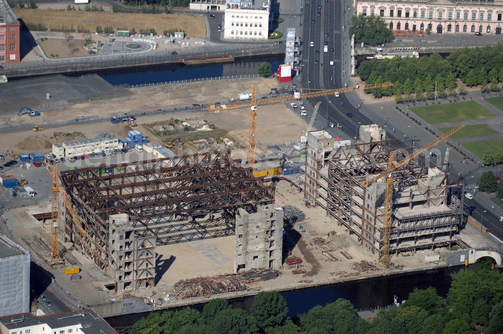 Berlin from the bird's eye view: . Seit Februar 2006 wird der Palast langsam mit Hilfe von fünf Kränen abgerissen. Von einer Sprengung des Gebäudes wurde abgesehen, weil Beschädigungen umliegender Häuser durch den Auftrieb der Bodenwanne und das dadurch bedingte Absinken des Grundwasserspiegels befürchtet wurden. Stattdessen wird das abgetragene Material gemessen und dann im gleichen Maß mit Wasser versetzter Sand in die Bodenwanne geleitet. Die Abrissarbeiten sollten ursprünglich Mitte 2007 abgeschlossen sein. Nachdem im Laufe der Arbeiten an mehreren Stellen neuer Asbest gefunden wurde und sich der Abriss dadurch stark verlangsamte, wird mit Ende 2008 als frühestem Ende kalkuliert. Die Zusatzkosten in Höhe von bislang 9,9 Mio. Euro muss der Bund übernehmen. Nach der vollständigen Abtragung soll vorübergehend eine Grünfläche über der verbleibenden Bodenwanne entstehen.