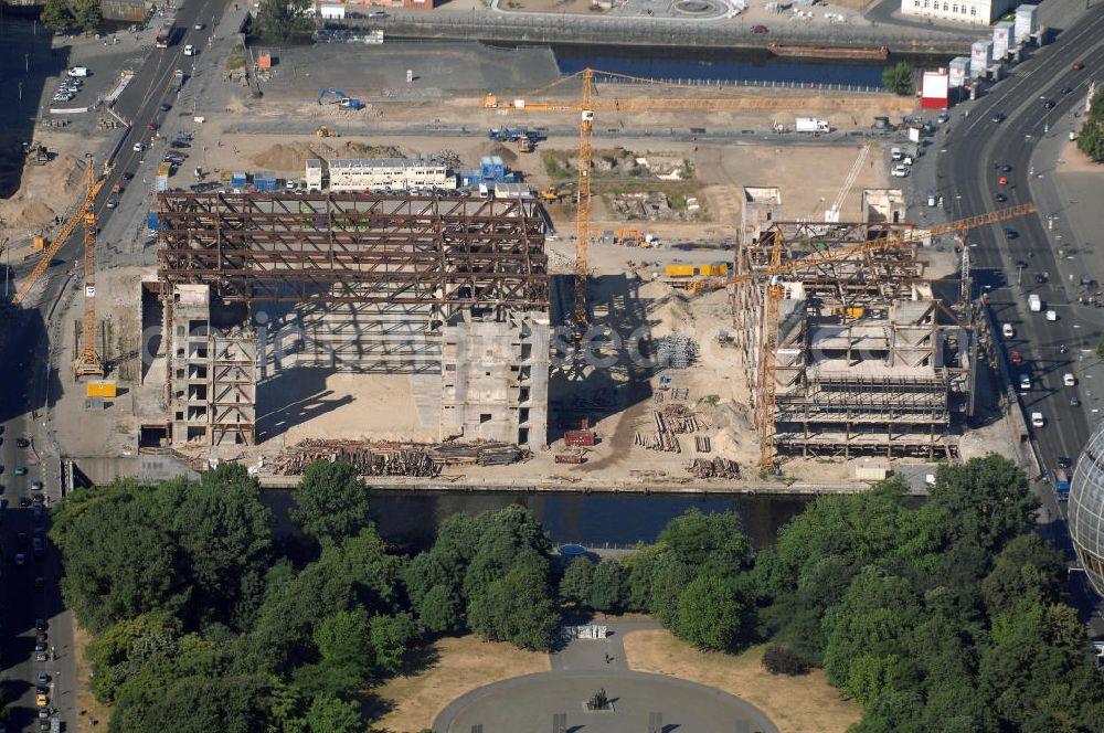 Aerial image Berlin - . Seit Februar 2006 wird der Palast langsam mit Hilfe von fünf Kränen abgerissen. Von einer Sprengung des Gebäudes wurde abgesehen, weil Beschädigungen umliegender Häuser durch den Auftrieb der Bodenwanne und das dadurch bedingte Absinken des Grundwasserspiegels befürchtet wurden. Stattdessen wird das abgetragene Material gemessen und dann im gleichen Maß mit Wasser versetzter Sand in die Bodenwanne geleitet. Die Abrissarbeiten sollten ursprünglich Mitte 2007 abgeschlossen sein. Nachdem im Laufe der Arbeiten an mehreren Stellen neuer Asbest gefunden wurde und sich der Abriss dadurch stark verlangsamte, wird mit Ende 2008 als frühestem Ende kalkuliert. Die Zusatzkosten in Höhe von bislang 9,9 Mio. Euro muss der Bund übernehmen. Nach der vollständigen Abtragung soll vorübergehend eine Grünfläche über der verbleibenden Bodenwanne entstehen.