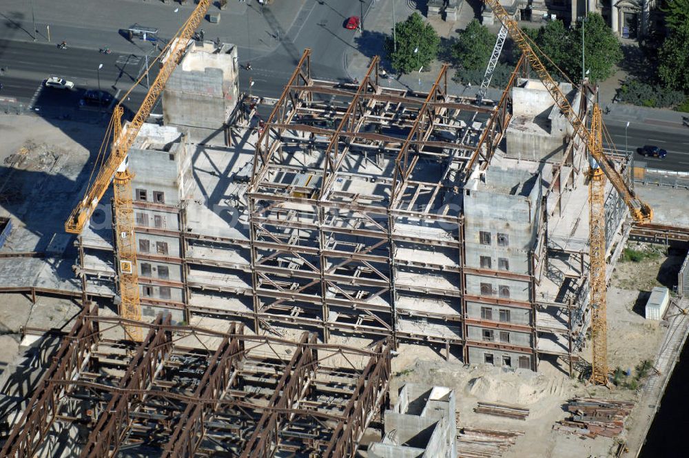 Berlin from the bird's eye view: . Seit Februar 2006 wird der Palast langsam mit Hilfe von fünf Kränen abgerissen. Von einer Sprengung des Gebäudes wurde abgesehen, weil Beschädigungen umliegender Häuser durch den Auftrieb der Bodenwanne und das dadurch bedingte Absinken des Grundwasserspiegels befürchtet wurden. Stattdessen wird das abgetragene Material gemessen und dann im gleichen Maß mit Wasser versetzter Sand in die Bodenwanne geleitet. Die Abrissarbeiten sollten ursprünglich Mitte 2007 abgeschlossen sein. Nachdem im Laufe der Arbeiten an mehreren Stellen neuer Asbest gefunden wurde und sich der Abriss dadurch stark verlangsamte, wird mit Ende 2008 als frühestem Ende kalkuliert. Die Zusatzkosten in Höhe von bislang 9,9 Mio. Euro muss der Bund übernehmen. Nach der vollständigen Abtragung soll vorübergehend eine Grünfläche über der verbleibenden Bodenwanne entstehen.