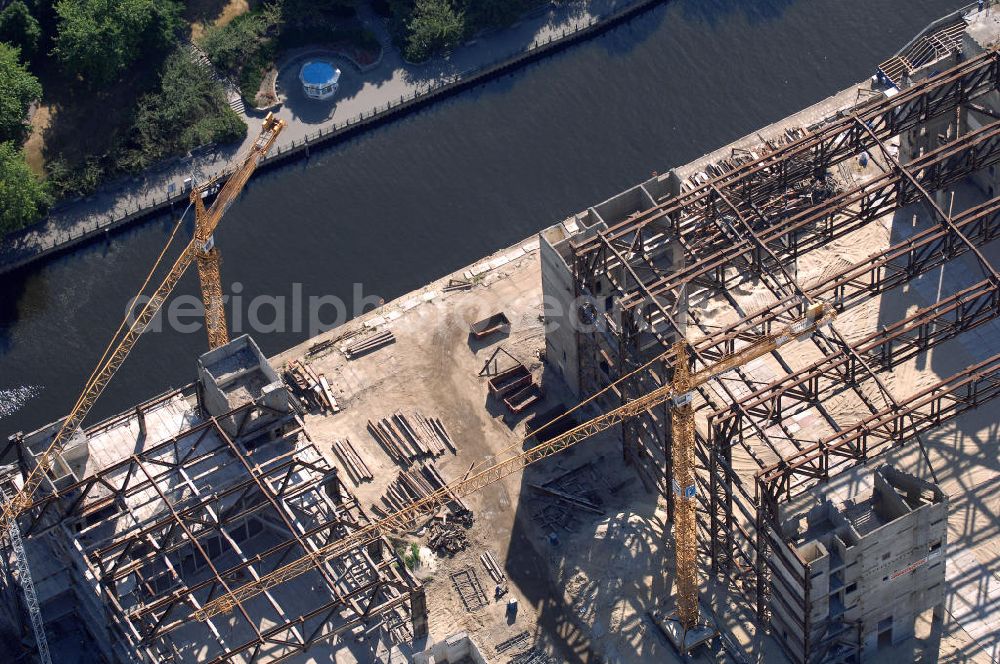 Aerial image Berlin - . Seit Februar 2006 wird der Palast langsam mit Hilfe von fünf Kränen abgerissen. Von einer Sprengung des Gebäudes wurde abgesehen, weil Beschädigungen umliegender Häuser durch den Auftrieb der Bodenwanne und das dadurch bedingte Absinken des Grundwasserspiegels befürchtet wurden. Stattdessen wird das abgetragene Material gemessen und dann im gleichen Maß mit Wasser versetzter Sand in die Bodenwanne geleitet. Die Abrissarbeiten sollten ursprünglich Mitte 2007 abgeschlossen sein. Nachdem im Laufe der Arbeiten an mehreren Stellen neuer Asbest gefunden wurde und sich der Abriss dadurch stark verlangsamte, wird mit Ende 2008 als frühestem Ende kalkuliert. Die Zusatzkosten in Höhe von bislang 9,9 Mio. Euro muss der Bund übernehmen. Nach der vollständigen Abtragung soll vorübergehend eine Grünfläche über der verbleibenden Bodenwanne entstehen.