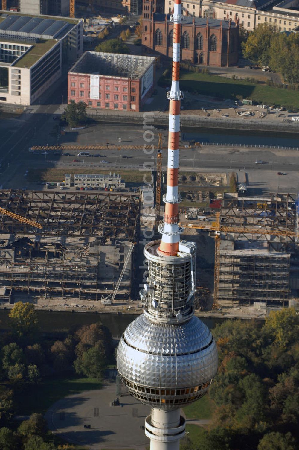 Berlin from the bird's eye view: Blick auf den Abriss des Palast der Republik in Mitte.Der Rückbau des Palastes der Republik verschob sich immer wieder. Am 19. Januar 2006 beschloss der Deutsche Bundestag, Anträgen der Grünen und der Linkspartei zur Verschiebung des Abrisses bzw. zur Erhaltung des Bauwerks nicht stattzugeben.Nach Terminen im Frühjahr 2005 und im Oktober 2005 wird das Gebäude seit Februar 2006 langsam mithilfe von fünf Kränen zurückgebaut. Von einer Sprengung des Gebäudes wurde abgesehen, weil Beschädigungen umliegender Gebäude durch den Auftrieb der Bodenwanne und das dadurch bedingte Absinken des Grundwasserspiegels befürchtet wurden. Stattdessen wird das abgetragene Material gemessen und im gleichen Maß dann mit Wasser versetzter Sand in die Bodenwanne geleitet. Die Abrissarbeiten sollten ursprünglich Mitte 2007 abgeschlossen sein. Nachdem im Laufe der Arbeiten an mehreren Stellen neues Asbest gefunden wurde und sich der Abriss dadurch stark verlangsamte, wird mit Ende 2008 als frühestes Ende kalkuliert. Die Zusatzkosten in Höhe von bislang 9,9 Mio. Euro muss der Bund übernehmen.Nach der vollständigen Abtragung soll vorübergehend eine Grünfläche über der verbleibenden Bodenwanne entstehen. Diskutiert wird auch eine Zwischennutzung der Fläche durch eine Kunsthalle.