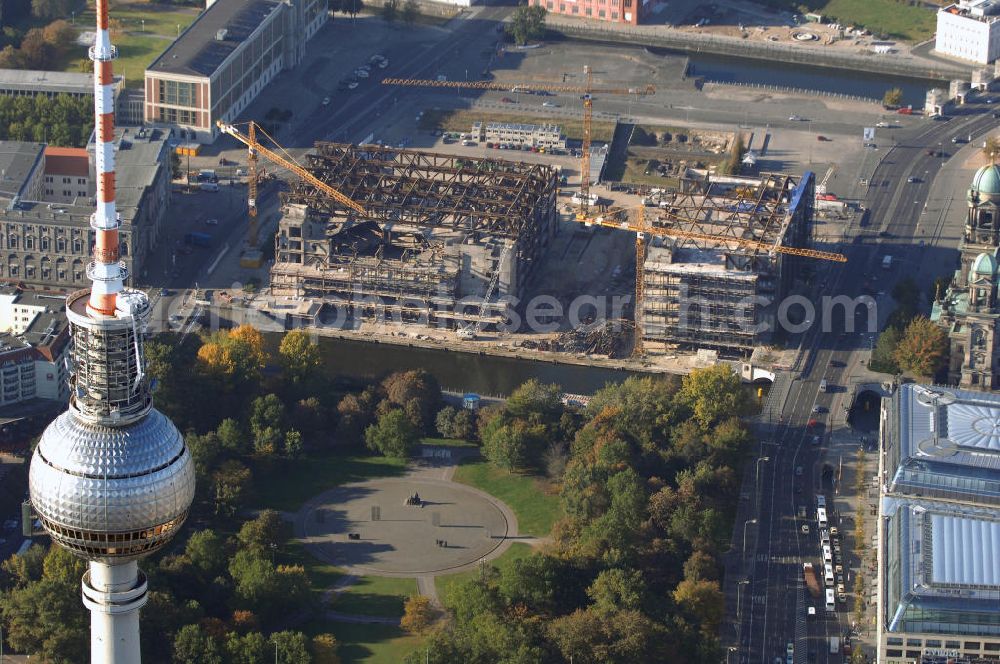 Aerial photograph Berlin - Blick auf den Abriss des Palast der Republik in Mitte.Der Rückbau des Palastes der Republik verschob sich immer wieder. Am 19. Januar 2006 beschloss der Deutsche Bundestag, Anträgen der Grünen und der Linkspartei zur Verschiebung des Abrisses bzw. zur Erhaltung des Bauwerks nicht stattzugeben.Nach Terminen im Frühjahr 2005 und im Oktober 2005 wird das Gebäude seit Februar 2006 langsam mithilfe von fünf Kränen zurückgebaut. Von einer Sprengung des Gebäudes wurde abgesehen, weil Beschädigungen umliegender Gebäude durch den Auftrieb der Bodenwanne und das dadurch bedingte Absinken des Grundwasserspiegels befürchtet wurden. Stattdessen wird das abgetragene Material gemessen und im gleichen Maß dann mit Wasser versetzter Sand in die Bodenwanne geleitet. Die Abrissarbeiten sollten ursprünglich Mitte 2007 abgeschlossen sein. Nachdem im Laufe der Arbeiten an mehreren Stellen neues Asbest gefunden wurde und sich der Abriss dadurch stark verlangsamte, wird mit Ende 2008 als frühestes Ende kalkuliert. Die Zusatzkosten in Höhe von bislang 9,9 Mio. Euro muss der Bund übernehmen.Nach der vollständigen Abtragung soll vorübergehend eine Grünfläche über der verbleibenden Bodenwanne entstehen. Diskutiert wird auch eine Zwischennutzung der Fläche durch eine Kunsthalle.