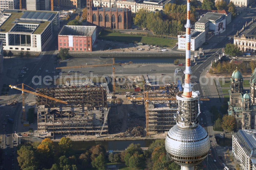 Aerial photograph Berlin - Blick auf den Abriss des Palast der Republik in Mitte.Der Rückbau des Palastes der Republik verschob sich immer wieder. Am 19. Januar 2006 beschloss der Deutsche Bundestag, Anträgen der Grünen und der Linkspartei zur Verschiebung des Abrisses bzw. zur Erhaltung des Bauwerks nicht stattzugeben.Nach Terminen im Frühjahr 2005 und im Oktober 2005 wird das Gebäude seit Februar 2006 langsam mithilfe von fünf Kränen zurückgebaut. Von einer Sprengung des Gebäudes wurde abgesehen, weil Beschädigungen umliegender Gebäude durch den Auftrieb der Bodenwanne und das dadurch bedingte Absinken des Grundwasserspiegels befürchtet wurden. Stattdessen wird das abgetragene Material gemessen und im gleichen Maß dann mit Wasser versetzter Sand in die Bodenwanne geleitet. Die Abrissarbeiten sollten ursprünglich Mitte 2007 abgeschlossen sein. Nachdem im Laufe der Arbeiten an mehreren Stellen neues Asbest gefunden wurde und sich der Abriss dadurch stark verlangsamte, wird mit Ende 2008 als frühestes Ende kalkuliert. Die Zusatzkosten in Höhe von bislang 9,9 Mio. Euro muss der Bund übernehmen.Nach der vollständigen Abtragung soll vorübergehend eine Grünfläche über der verbleibenden Bodenwanne entstehen. Diskutiert wird auch eine Zwischennutzung der Fläche durch eine Kunsthalle.