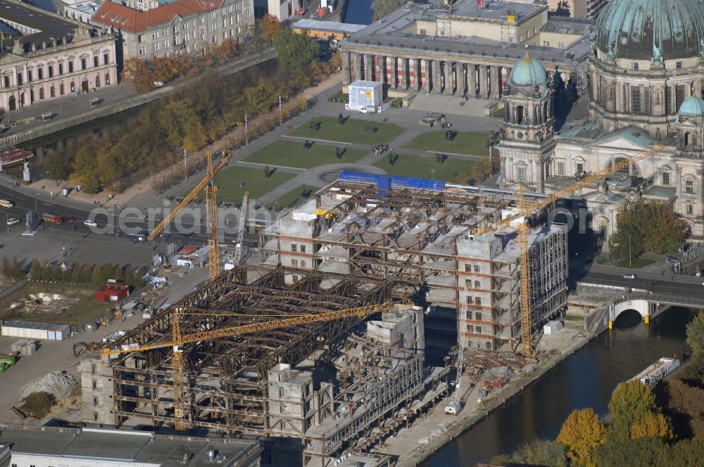 Berlin from the bird's eye view: Blick auf den Abriss des Palast der Republik in Mitte.Der Rückbau des Palastes der Republik verschob sich immer wieder. Am 19. Januar 2006 beschloss der Deutsche Bundestag, Anträgen der Grünen und der Linkspartei zur Verschiebung des Abrisses bzw. zur Erhaltung des Bauwerks nicht stattzugeben.Nach Terminen im Frühjahr 2005 und im Oktober 2005 wird das Gebäude seit Februar 2006 langsam mithilfe von fünf Kränen zurückgebaut. Von einer Sprengung des Gebäudes wurde abgesehen, weil Beschädigungen umliegender Gebäude durch den Auftrieb der Bodenwanne und das dadurch bedingte Absinken des Grundwasserspiegels befürchtet wurden. Stattdessen wird das abgetragene Material gemessen und im gleichen Maß dann mit Wasser versetzter Sand in die Bodenwanne geleitet. Die Abrissarbeiten sollten ursprünglich Mitte 2007 abgeschlossen sein. Nachdem im Laufe der Arbeiten an mehreren Stellen neues Asbest gefunden wurde und sich der Abriss dadurch stark verlangsamte, wird mit Ende 2008 als frühestes Ende kalkuliert. Die Zusatzkosten in Höhe von bislang 9,9 Mio. Euro muss der Bund übernehmen.Nach der vollständigen Abtragung soll vorübergehend eine Grünfläche über der verbleibenden Bodenwanne entstehen. Diskutiert wird auch eine Zwischennutzung der Fläche durch eine Kunsthalle.