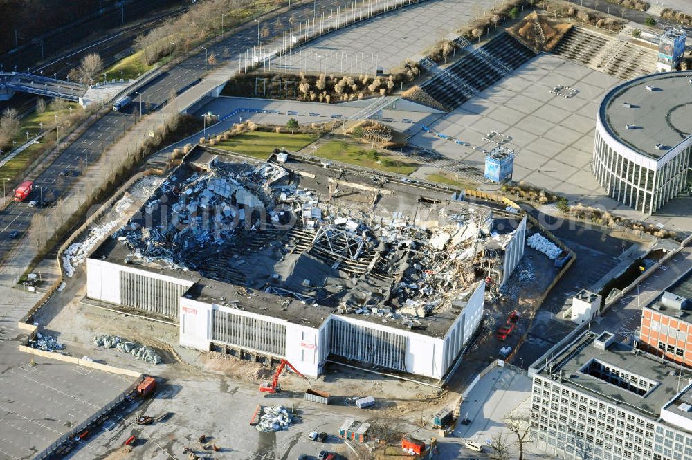 Aerial photograph Berlin - Blick auf die Abrißarbeiten an der ehemaligen Deutschlandhalle an der Jaffeystraße auf dem Messegelände in Charlottenburg. Abbruch-Bagger der Berliner Firma „ RWG1 “ setzten sie ihre tonnenschweren Kneifzangen in Betrieb und hackten sich in den Beton. Begonnen wurde mit dem Fassaden-Abriss an der Nordseite der Halle mit Abbruch-Bagger der Marke „ Liebherr “, Modelle 954 und 974. Sie wiegen 87 bis 140 Tonnen, haben bis zu 543 PS, nehmen die Fassade mit verschiedenen Greif- und Kneifbacken in die Zange. Der Abbruch soll bis März des Folgejahres beendet sein, um die nötige Baufreiheit für die Grundsteinlegung einer neuen Kongress- und Messehalle der Messe Berlin zu gewährleisten. Demolition work of the former Germany Halle Jaffeystraße on the fairgrounds in Charlottenburg.