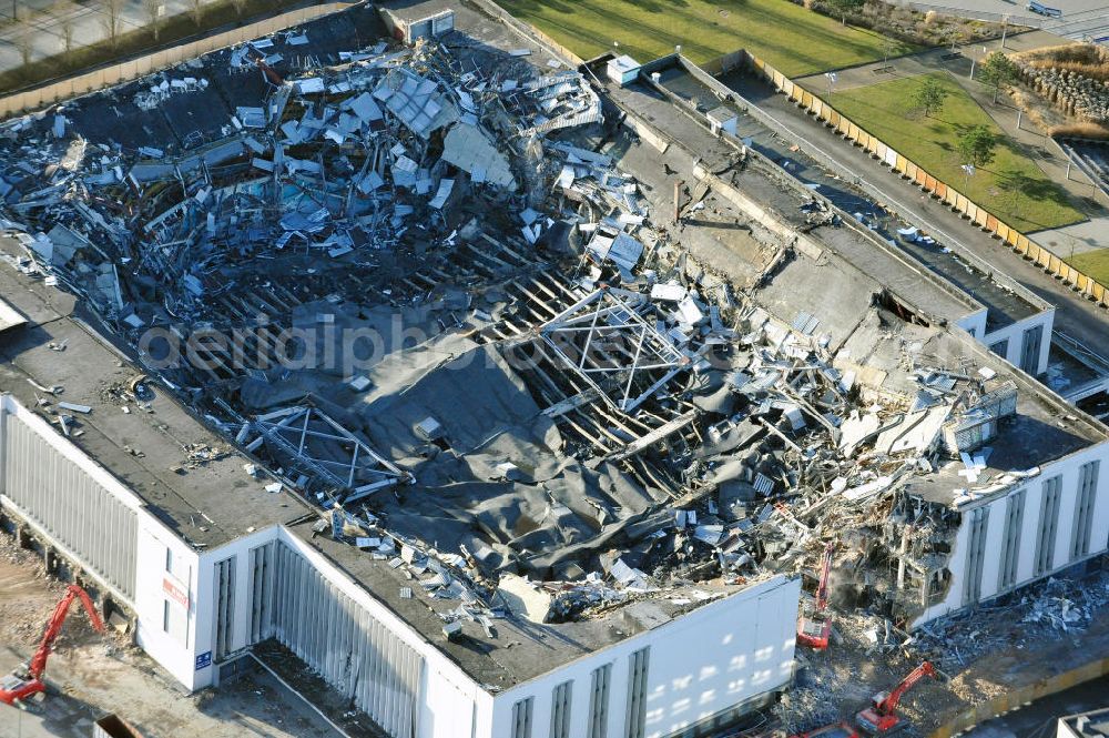 Berlin from above - Blick auf die Abrißarbeiten an der ehemaligen Deutschlandhalle an der Jaffeystraße auf dem Messegelände in Charlottenburg. Abbruch-Bagger der Berliner Firma „ RWG1 “ setzten sie ihre tonnenschweren Kneifzangen in Betrieb und hackten sich in den Beton. Begonnen wurde mit dem Fassaden-Abriss an der Nordseite der Halle mit Abbruch-Bagger der Marke „ Liebherr “, Modelle 954 und 974. Sie wiegen 87 bis 140 Tonnen, haben bis zu 543 PS, nehmen die Fassade mit verschiedenen Greif- und Kneifbacken in die Zange. Der Abbruch soll bis März des Folgejahres beendet sein, um die nötige Baufreiheit für die Grundsteinlegung einer neuen Kongress- und Messehalle der Messe Berlin zu gewährleisten. Demolition work of the former Germany Halle Jaffeystraße on the fairgrounds in Charlottenburg.