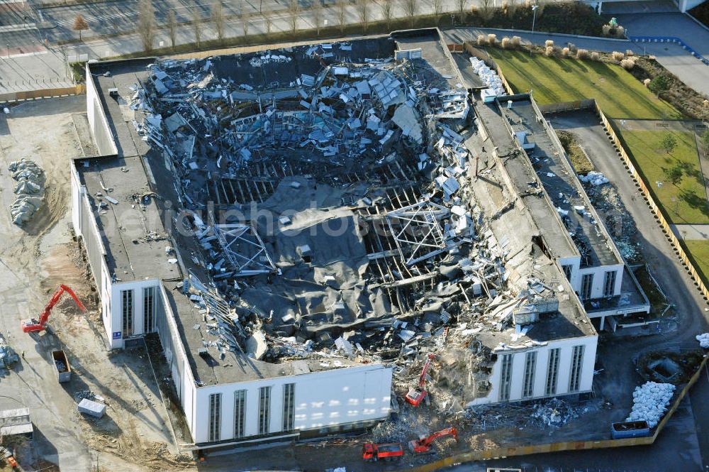 Berlin from the bird's eye view: Blick auf die Abrißarbeiten an der ehemaligen Deutschlandhalle an der Jaffeystraße auf dem Messegelände in Charlottenburg. Abbruch-Bagger der Berliner Firma „ RWG1 “ setzten sie ihre tonnenschweren Kneifzangen in Betrieb und hackten sich in den Beton. Begonnen wurde mit dem Fassaden-Abriss an der Nordseite der Halle mit Abbruch-Bagger der Marke „ Liebherr “, Modelle 954 und 974. Sie wiegen 87 bis 140 Tonnen, haben bis zu 543 PS, nehmen die Fassade mit verschiedenen Greif- und Kneifbacken in die Zange. Der Abbruch soll bis März des Folgejahres beendet sein, um die nötige Baufreiheit für die Grundsteinlegung einer neuen Kongress- und Messehalle der Messe Berlin zu gewährleisten. Demolition work of the former Germany Halle Jaffeystraße on the fairgrounds in Charlottenburg.