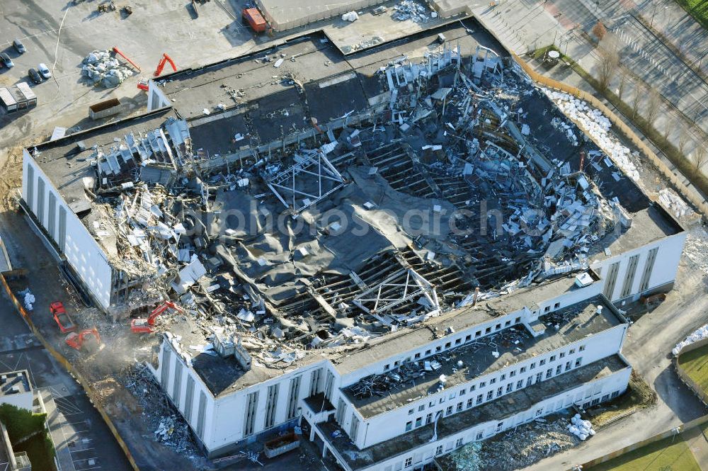 Aerial photograph Berlin - Blick auf die Abrißarbeiten an der ehemaligen Deutschlandhalle an der Jaffeystraße auf dem Messegelände in Charlottenburg. Abbruch-Bagger der Berliner Firma „ RWG1 “ setzten sie ihre tonnenschweren Kneifzangen in Betrieb und hackten sich in den Beton. Begonnen wurde mit dem Fassaden-Abriss an der Nordseite der Halle mit Abbruch-Bagger der Marke „ Liebherr “, Modelle 954 und 974. Sie wiegen 87 bis 140 Tonnen, haben bis zu 543 PS, nehmen die Fassade mit verschiedenen Greif- und Kneifbacken in die Zange. Der Abbruch soll bis März des Folgejahres beendet sein, um die nötige Baufreiheit für die Grundsteinlegung einer neuen Kongress- und Messehalle der Messe Berlin zu gewährleisten. Demolition work of the former Germany Halle Jaffeystraße on the fairgrounds in Charlottenburg.