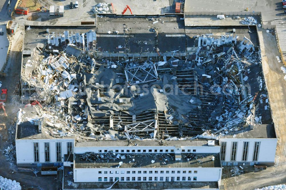 Berlin from above - Blick auf die Abrißarbeiten an der ehemaligen Deutschlandhalle an der Jaffeystraße auf dem Messegelände in Charlottenburg. Abbruch-Bagger der Berliner Firma „ RWG1 “ setzten sie ihre tonnenschweren Kneifzangen in Betrieb und hackten sich in den Beton. Begonnen wurde mit dem Fassaden-Abriss an der Nordseite der Halle mit Abbruch-Bagger der Marke „ Liebherr “, Modelle 954 und 974. Sie wiegen 87 bis 140 Tonnen, haben bis zu 543 PS, nehmen die Fassade mit verschiedenen Greif- und Kneifbacken in die Zange. Der Abbruch soll bis März des Folgejahres beendet sein, um die nötige Baufreiheit für die Grundsteinlegung einer neuen Kongress- und Messehalle der Messe Berlin zu gewährleisten. Demolition work of the former Germany Halle Jaffeystraße on the fairgrounds in Charlottenburg.