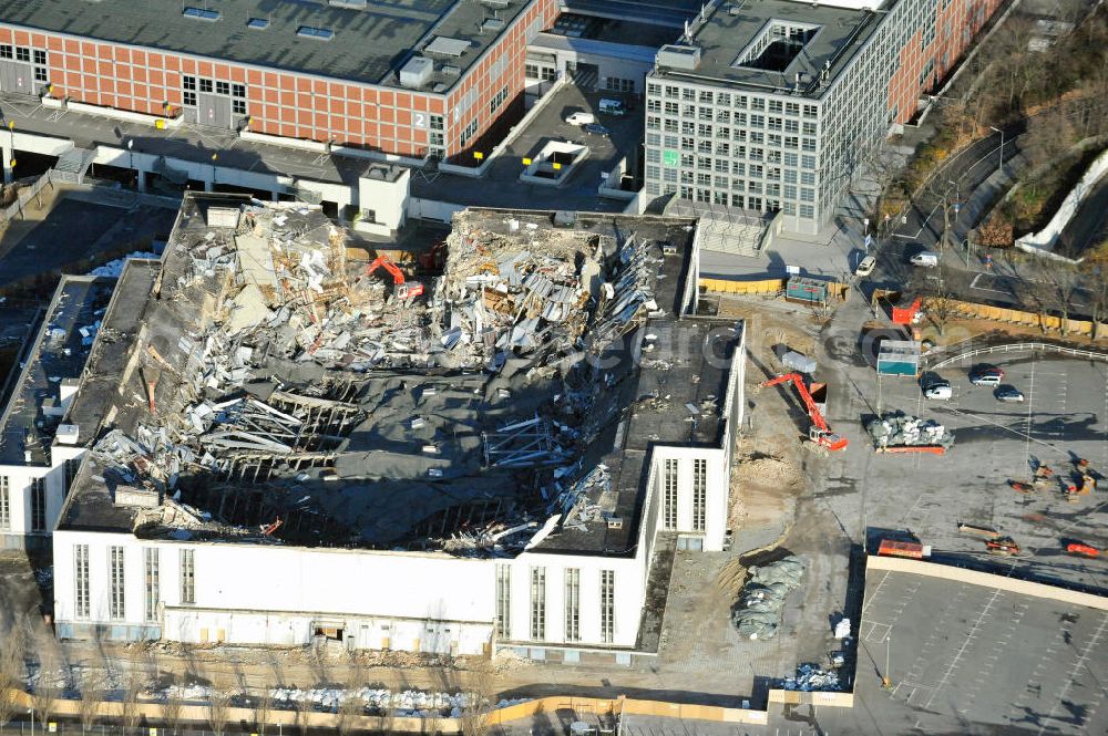 Aerial photograph Berlin - Blick auf die Abrißarbeiten an der ehemaligen Deutschlandhalle an der Jaffeystraße auf dem Messegelände in Charlottenburg. Abbruch-Bagger der Berliner Firma „ RWG1 “ setzten sie ihre tonnenschweren Kneifzangen in Betrieb und hackten sich in den Beton. Begonnen wurde mit dem Fassaden-Abriss an der Nordseite der Halle mit Abbruch-Bagger der Marke „ Liebherr “, Modelle 954 und 974. Sie wiegen 87 bis 140 Tonnen, haben bis zu 543 PS, nehmen die Fassade mit verschiedenen Greif- und Kneifbacken in die Zange. Der Abbruch soll bis März des Folgejahres beendet sein, um die nötige Baufreiheit für die Grundsteinlegung einer neuen Kongress- und Messehalle der Messe Berlin zu gewährleisten. Demolition work of the former Germany Halle Jaffeystraße on the fairgrounds in Charlottenburg.