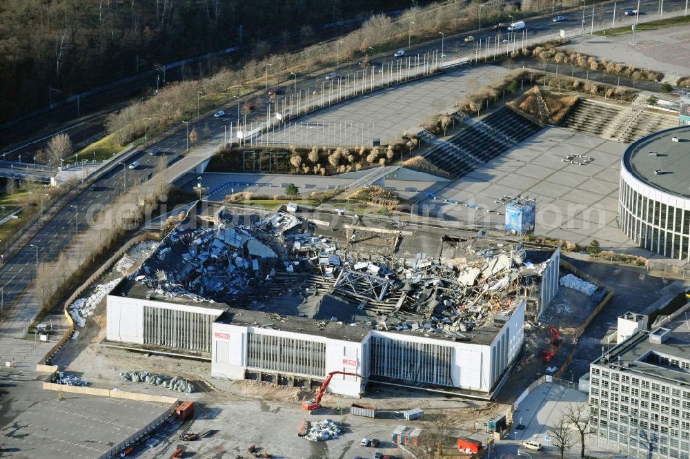 Aerial photograph Berlin - Blick auf die Abrißarbeiten an der ehemaligen Deutschlandhalle an der Jaffeystraße auf dem Messegelände in Charlottenburg. Abbruch-Bagger der Berliner Firma „ RWG1 “ setzten sie ihre tonnenschweren Kneifzangen in Betrieb und hackten sich in den Beton. Begonnen wurde mit dem Fassaden-Abriss an der Nordseite der Halle mit Abbruch-Bagger der Marke „ Liebherr “, Modelle 954 und 974. Sie wiegen 87 bis 140 Tonnen, haben bis zu 543 PS, nehmen die Fassade mit verschiedenen Greif- und Kneifbacken in die Zange. Der Abbruch soll bis März des Folgejahres beendet sein, um die nötige Baufreiheit für die Grundsteinlegung einer neuen Kongress- und Messehalle der Messe Berlin zu gewährleisten. Demolition work of the former Germany Halle Jaffeystraße on the fairgrounds in Charlottenburg.