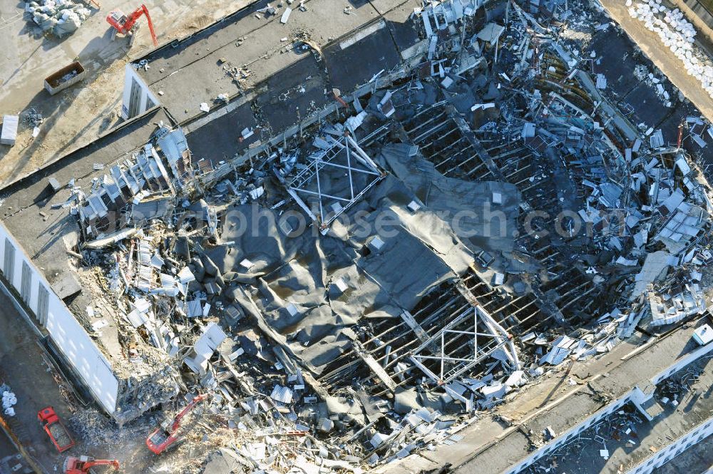 Berlin from above - Blick auf die Abrißarbeiten an der ehemaligen Deutschlandhalle an der Jaffeystraße auf dem Messegelände in Charlottenburg. Abbruch-Bagger der Berliner Firma „ RWG1 “ setzten sie ihre tonnenschweren Kneifzangen in Betrieb und hackten sich in den Beton. Begonnen wurde mit dem Fassaden-Abriss an der Nordseite der Halle mit Abbruch-Bagger der Marke „ Liebherr “, Modelle 954 und 974. Sie wiegen 87 bis 140 Tonnen, haben bis zu 543 PS, nehmen die Fassade mit verschiedenen Greif- und Kneifbacken in die Zange. Der Abbruch soll bis März des Folgejahres beendet sein, um die nötige Baufreiheit für die Grundsteinlegung einer neuen Kongress- und Messehalle der Messe Berlin zu gewährleisten. Demolition work of the former Germany Halle Jaffeystraße on the fairgrounds in Charlottenburg.