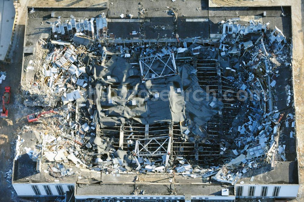 Berlin from the bird's eye view: Blick auf die Abrißarbeiten an der ehemaligen Deutschlandhalle an der Jaffeystraße auf dem Messegelände in Charlottenburg. Abbruch-Bagger der Berliner Firma „ RWG1 “ setzten sie ihre tonnenschweren Kneifzangen in Betrieb und hackten sich in den Beton. Begonnen wurde mit dem Fassaden-Abriss an der Nordseite der Halle mit Abbruch-Bagger der Marke „ Liebherr “, Modelle 954 und 974. Sie wiegen 87 bis 140 Tonnen, haben bis zu 543 PS, nehmen die Fassade mit verschiedenen Greif- und Kneifbacken in die Zange. Der Abbruch soll bis März des Folgejahres beendet sein, um die nötige Baufreiheit für die Grundsteinlegung einer neuen Kongress- und Messehalle der Messe Berlin zu gewährleisten. Demolition work of the former Germany Halle Jaffeystraße on the fairgrounds in Charlottenburg.