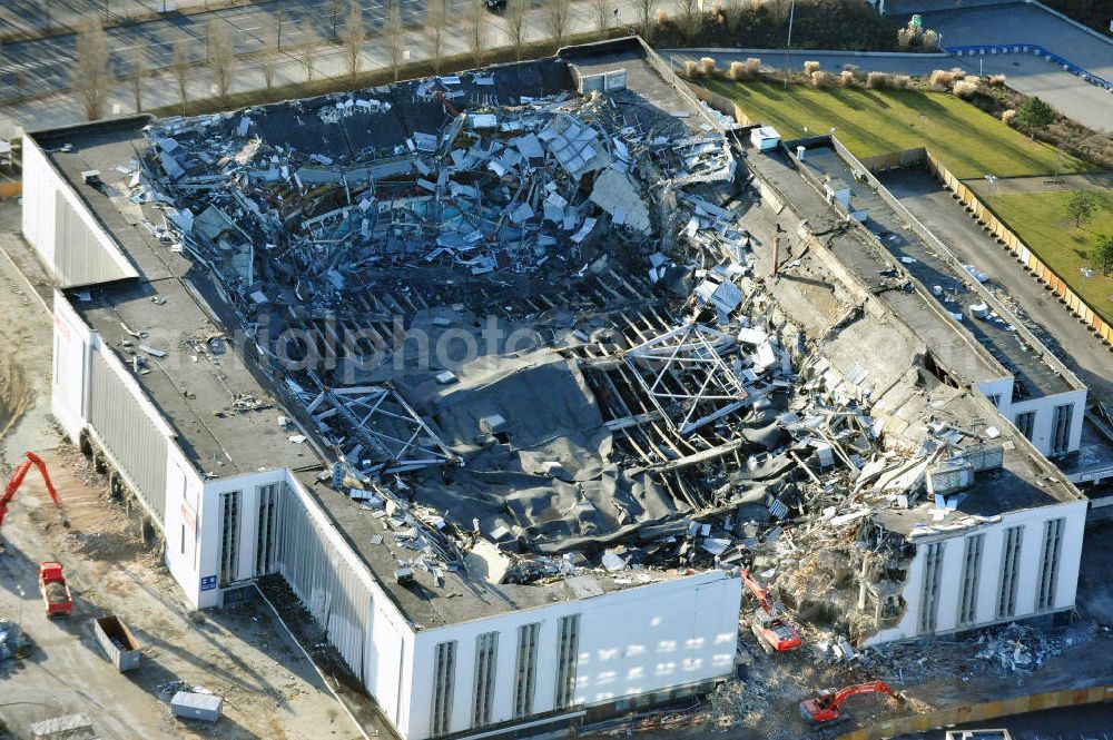 Aerial photograph Berlin - Blick auf die Abrißarbeiten an der ehemaligen Deutschlandhalle an der Jaffeystraße auf dem Messegelände in Charlottenburg. Abbruch-Bagger der Berliner Firma „ RWG1 “ setzten sie ihre tonnenschweren Kneifzangen in Betrieb und hackten sich in den Beton. Begonnen wurde mit dem Fassaden-Abriss an der Nordseite der Halle mit Abbruch-Bagger der Marke „ Liebherr “, Modelle 954 und 974. Sie wiegen 87 bis 140 Tonnen, haben bis zu 543 PS, nehmen die Fassade mit verschiedenen Greif- und Kneifbacken in die Zange. Der Abbruch soll bis März des Folgejahres beendet sein, um die nötige Baufreiheit für die Grundsteinlegung einer neuen Kongress- und Messehalle der Messe Berlin zu gewährleisten. Demolition work of the former Germany Halle Jaffeystraße on the fairgrounds in Charlottenburg.