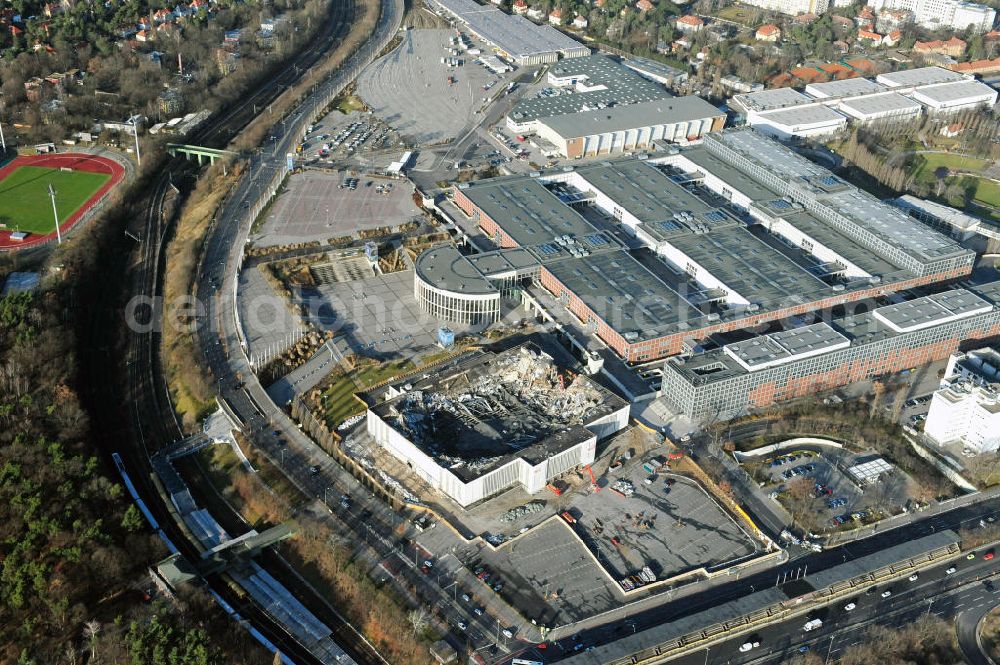 Aerial photograph Berlin - Blick auf die Abrißarbeiten an der ehemaligen Deutschlandhalle an der Jaffeystraße auf dem Messegelände in Charlottenburg. Abbruch-Bagger der Berliner Firma „ RWG1 “ setzten sie ihre tonnenschweren Kneifzangen in Betrieb und hackten sich in den Beton. Begonnen wurde mit dem Fassaden-Abriss an der Nordseite der Halle mit Abbruch-Bagger der Marke „ Liebherr “, Modelle 954 und 974. Sie wiegen 87 bis 140 Tonnen, haben bis zu 543 PS, nehmen die Fassade mit verschiedenen Greif- und Kneifbacken in die Zange. Der Abbruch soll bis März des Folgejahres beendet sein, um die nötige Baufreiheit für die Grundsteinlegung einer neuen Kongress- und Messehalle der Messe Berlin zu gewährleisten. Demolition work of the former Germany Halle Jaffeystraße on the fairgrounds in Charlottenburg.