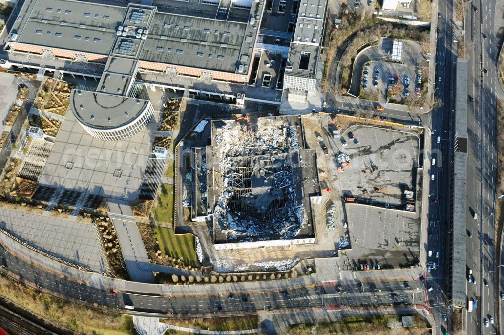 Berlin from above - Blick auf die Abrißarbeiten an der ehemaligen Deutschlandhalle an der Jaffeystraße auf dem Messegelände in Charlottenburg. Abbruch-Bagger der Berliner Firma „ RWG1 “ setzten sie ihre tonnenschweren Kneifzangen in Betrieb und hackten sich in den Beton. Begonnen wurde mit dem Fassaden-Abriss an der Nordseite der Halle mit Abbruch-Bagger der Marke „ Liebherr “, Modelle 954 und 974. Sie wiegen 87 bis 140 Tonnen, haben bis zu 543 PS, nehmen die Fassade mit verschiedenen Greif- und Kneifbacken in die Zange. Der Abbruch soll bis März des Folgejahres beendet sein, um die nötige Baufreiheit für die Grundsteinlegung einer neuen Kongress- und Messehalle der Messe Berlin zu gewährleisten. Demolition work of the former Germany Halle Jaffeystraße on the fairgrounds in Charlottenburg.