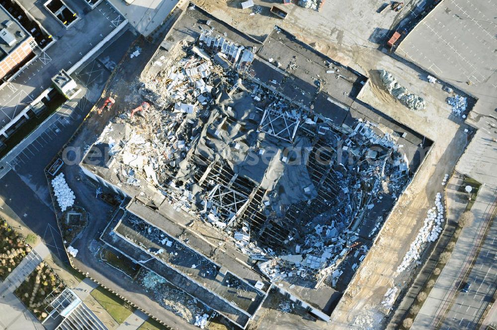 Aerial image Berlin - Blick auf die Abrißarbeiten an der ehemaligen Deutschlandhalle an der Jaffeystraße auf dem Messegelände in Charlottenburg. Abbruch-Bagger der Berliner Firma „ RWG1 “ setzten sie ihre tonnenschweren Kneifzangen in Betrieb und hackten sich in den Beton. Begonnen wurde mit dem Fassaden-Abriss an der Nordseite der Halle mit Abbruch-Bagger der Marke „ Liebherr “, Modelle 954 und 974. Sie wiegen 87 bis 140 Tonnen, haben bis zu 543 PS, nehmen die Fassade mit verschiedenen Greif- und Kneifbacken in die Zange. Der Abbruch soll bis März des Folgejahres beendet sein, um die nötige Baufreiheit für die Grundsteinlegung einer neuen Kongress- und Messehalle der Messe Berlin zu gewährleisten. Demolition work of the former Germany Halle Jaffeystraße on the fairgrounds in Charlottenburg.