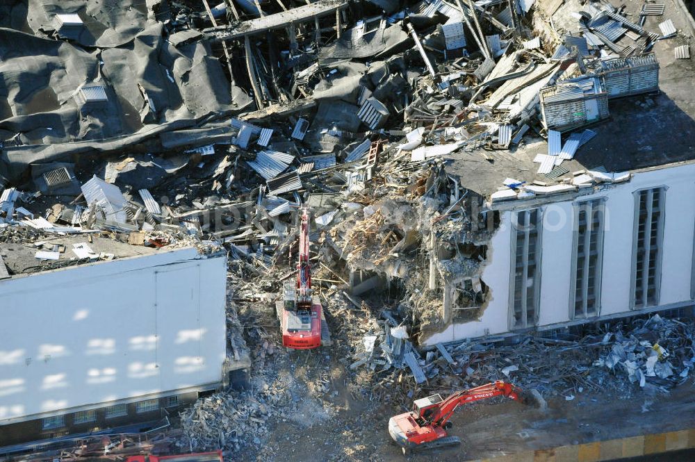 Aerial photograph Berlin - Blick auf die Abrißarbeiten an der ehemaligen Deutschlandhalle an der Jaffeystraße auf dem Messegelände in Charlottenburg. Abbruch-Bagger der Berliner Firma „ RWG1 “ setzten sie ihre tonnenschweren Kneifzangen in Betrieb und hackten sich in den Beton. Begonnen wurde mit dem Fassaden-Abriss an der Nordseite der Halle mit Abbruch-Bagger der Marke „ Liebherr “, Modelle 954 und 974. Sie wiegen 87 bis 140 Tonnen, haben bis zu 543 PS, nehmen die Fassade mit verschiedenen Greif- und Kneifbacken in die Zange. Der Abbruch soll bis März des Folgejahres beendet sein, um die nötige Baufreiheit für die Grundsteinlegung einer neuen Kongress- und Messehalle der Messe Berlin zu gewährleisten. Demolition work of the former Germany Halle Jaffeystraße on the fairgrounds in Charlottenburg.