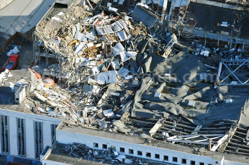 Berlin from above - Blick auf die Abrißarbeiten an der ehemaligen Deutschlandhalle an der Jaffeystraße auf dem Messegelände in Charlottenburg. Abbruch-Bagger der Berliner Firma „ RWG1 “ setzten sie ihre tonnenschweren Kneifzangen in Betrieb und hackten sich in den Beton. Begonnen wurde mit dem Fassaden-Abriss an der Nordseite der Halle mit Abbruch-Bagger der Marke „ Liebherr “, Modelle 954 und 974. Sie wiegen 87 bis 140 Tonnen, haben bis zu 543 PS, nehmen die Fassade mit verschiedenen Greif- und Kneifbacken in die Zange. Der Abbruch soll bis März des Folgejahres beendet sein, um die nötige Baufreiheit für die Grundsteinlegung einer neuen Kongress- und Messehalle der Messe Berlin zu gewährleisten. Demolition work of the former Germany Halle Jaffeystraße on the fairgrounds in Charlottenburg.