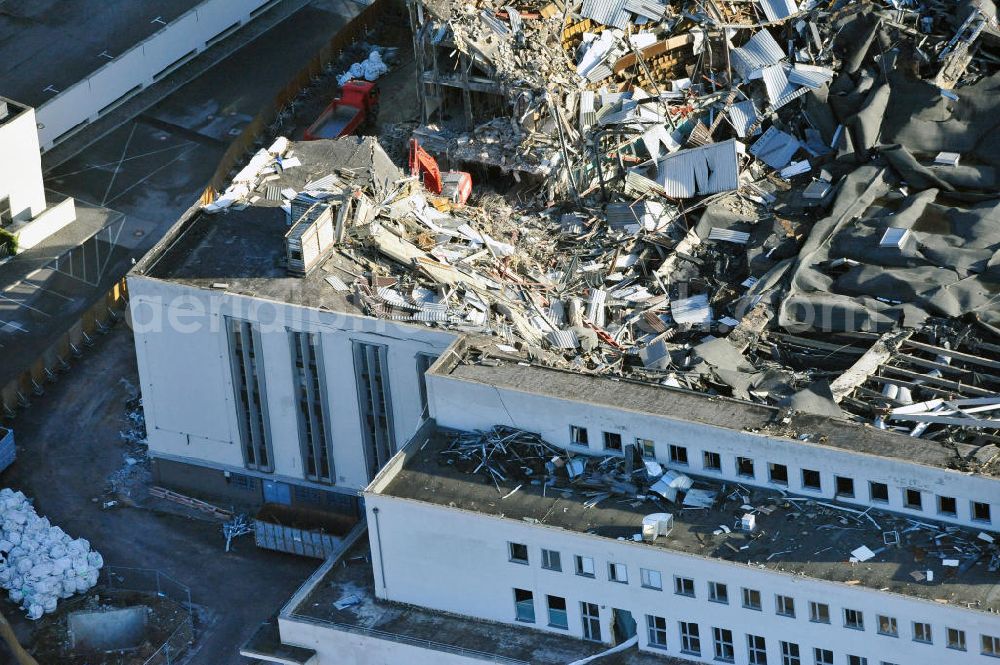 Berlin from the bird's eye view: Blick auf die Abrißarbeiten an der ehemaligen Deutschlandhalle an der Jaffeystraße auf dem Messegelände in Charlottenburg. Abbruch-Bagger der Berliner Firma „ RWG1 “ setzten sie ihre tonnenschweren Kneifzangen in Betrieb und hackten sich in den Beton. Begonnen wurde mit dem Fassaden-Abriss an der Nordseite der Halle mit Abbruch-Bagger der Marke „ Liebherr “, Modelle 954 und 974. Sie wiegen 87 bis 140 Tonnen, haben bis zu 543 PS, nehmen die Fassade mit verschiedenen Greif- und Kneifbacken in die Zange. Der Abbruch soll bis März des Folgejahres beendet sein, um die nötige Baufreiheit für die Grundsteinlegung einer neuen Kongress- und Messehalle der Messe Berlin zu gewährleisten. Demolition work of the former Germany Halle Jaffeystraße on the fairgrounds in Charlottenburg.