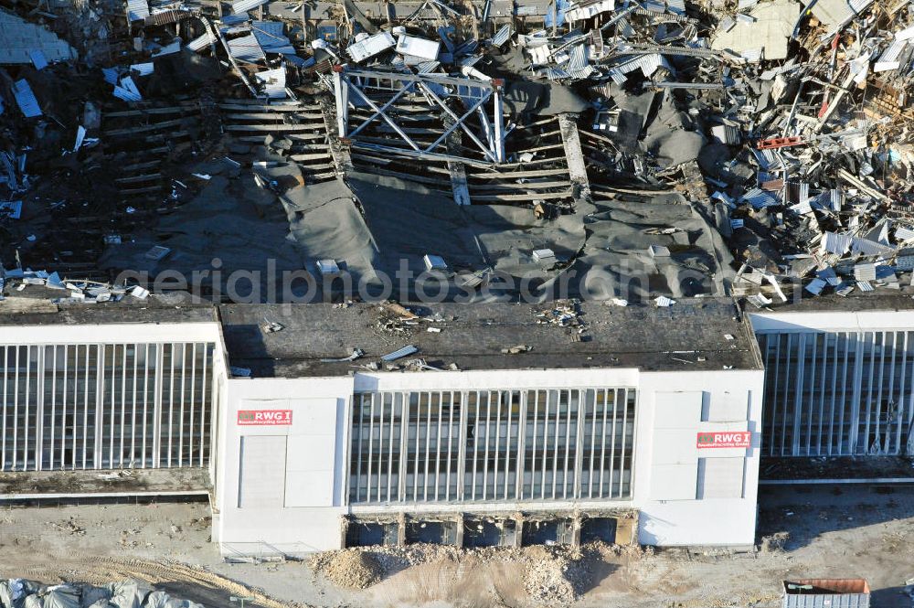 Aerial photograph Berlin - Blick auf die Abrißarbeiten an der ehemaligen Deutschlandhalle an der Jaffeystraße auf dem Messegelände in Charlottenburg. Abbruch-Bagger der Berliner Firma „ RWG1 “ setzten sie ihre tonnenschweren Kneifzangen in Betrieb und hackten sich in den Beton. Begonnen wurde mit dem Fassaden-Abriss an der Nordseite der Halle mit Abbruch-Bagger der Marke „ Liebherr “, Modelle 954 und 974. Sie wiegen 87 bis 140 Tonnen, haben bis zu 543 PS, nehmen die Fassade mit verschiedenen Greif- und Kneifbacken in die Zange. Der Abbruch soll bis März des Folgejahres beendet sein, um die nötige Baufreiheit für die Grundsteinlegung einer neuen Kongress- und Messehalle der Messe Berlin zu gewährleisten. Demolition work of the former Germany Halle Jaffeystraße on the fairgrounds in Charlottenburg.