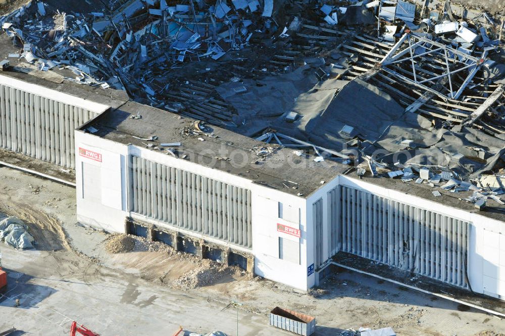 Berlin from above - Blick auf die Abrißarbeiten an der ehemaligen Deutschlandhalle an der Jaffeystraße auf dem Messegelände in Charlottenburg. Abbruch-Bagger der Berliner Firma „ RWG1 “ setzten sie ihre tonnenschweren Kneifzangen in Betrieb und hackten sich in den Beton. Begonnen wurde mit dem Fassaden-Abriss an der Nordseite der Halle mit Abbruch-Bagger der Marke „ Liebherr “, Modelle 954 und 974. Sie wiegen 87 bis 140 Tonnen, haben bis zu 543 PS, nehmen die Fassade mit verschiedenen Greif- und Kneifbacken in die Zange. Der Abbruch soll bis März des Folgejahres beendet sein, um die nötige Baufreiheit für die Grundsteinlegung einer neuen Kongress- und Messehalle der Messe Berlin zu gewährleisten. Demolition work of the former Germany Halle Jaffeystraße on the fairgrounds in Charlottenburg.