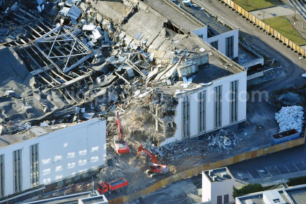 Berlin from the bird's eye view: Blick auf die Abrißarbeiten an der ehemaligen Deutschlandhalle an der Jaffeystraße auf dem Messegelände in Charlottenburg. Abbruch-Bagger der Berliner Firma „ RWG1 “ setzten sie ihre tonnenschweren Kneifzangen in Betrieb und hackten sich in den Beton. Begonnen wurde mit dem Fassaden-Abriss an der Nordseite der Halle mit Abbruch-Bagger der Marke „ Liebherr “, Modelle 954 und 974. Sie wiegen 87 bis 140 Tonnen, haben bis zu 543 PS, nehmen die Fassade mit verschiedenen Greif- und Kneifbacken in die Zange. Der Abbruch soll bis März des Folgejahres beendet sein, um die nötige Baufreiheit für die Grundsteinlegung einer neuen Kongress- und Messehalle der Messe Berlin zu gewährleisten. Demolition work of the former Germany Halle Jaffeystraße on the fairgrounds in Charlottenburg.