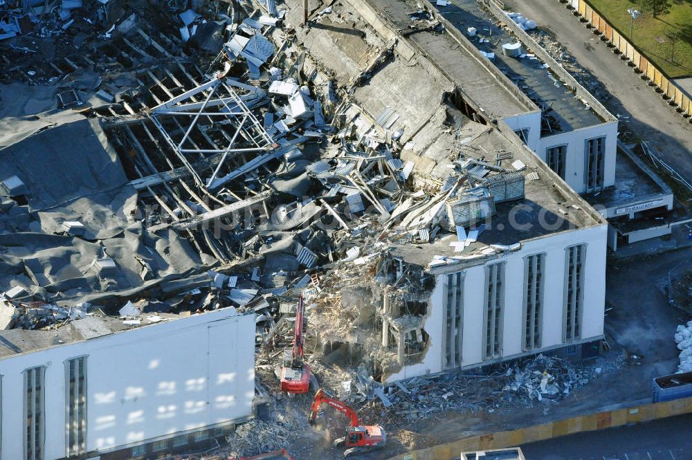 Aerial image Berlin - Blick auf die Abrißarbeiten an der ehemaligen Deutschlandhalle an der Jaffeystraße auf dem Messegelände in Charlottenburg. Abbruch-Bagger der Berliner Firma „ RWG1 “ setzten sie ihre tonnenschweren Kneifzangen in Betrieb und hackten sich in den Beton. Begonnen wurde mit dem Fassaden-Abriss an der Nordseite der Halle mit Abbruch-Bagger der Marke „ Liebherr “, Modelle 954 und 974. Sie wiegen 87 bis 140 Tonnen, haben bis zu 543 PS, nehmen die Fassade mit verschiedenen Greif- und Kneifbacken in die Zange. Der Abbruch soll bis März des Folgejahres beendet sein, um die nötige Baufreiheit für die Grundsteinlegung einer neuen Kongress- und Messehalle der Messe Berlin zu gewährleisten. Demolition work of the former Germany Halle Jaffeystraße on the fairgrounds in Charlottenburg.