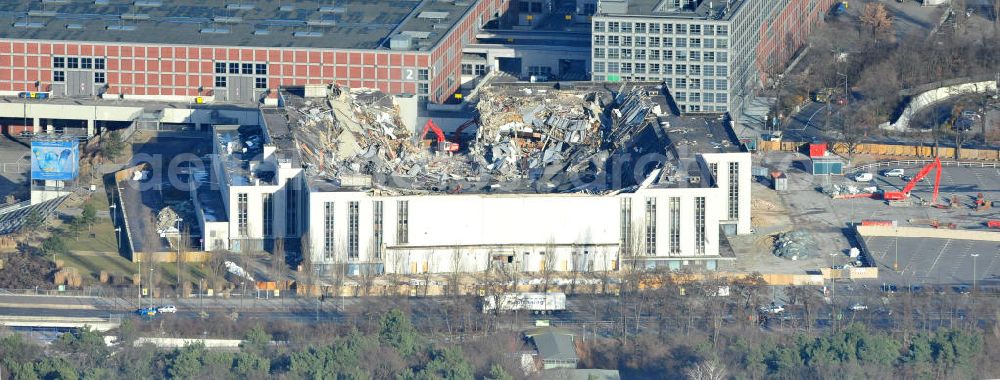 Berlin from the bird's eye view: Blick auf die Abrißarbeiten an der ehemaligen Deutschlandhalle an der Jaffeystraße auf dem Messegelände in Charlottenburg. Abbruch-Bagger der Berliner Firma „ RWG1 “ setzten sie ihre tonnenschweren Kneifzangen in Betrieb und hackten sich in den Beton. Begonnen wurde mit dem Fassaden-Abriss an der Nordseite der Halle mit Abbruch-Bagger der Marke „ Liebherr “, Modelle 954 und 974. Sie wiegen 87 bis 140 Tonnen, haben bis zu 543 PS, nehmen die Fassade mit verschiedenen Greif- und Kneifbacken in die Zange. Der Abbruch soll bis März des Folgejahres beendet sein, um die nötige Baufreiheit für die Grundsteinlegung einer neuen Kongress- und Messehalle der Messe Berlin zu gewährleisten. Demolition work of the former Germany Halle Jaffeystraße on the fairgrounds in Charlottenburg.