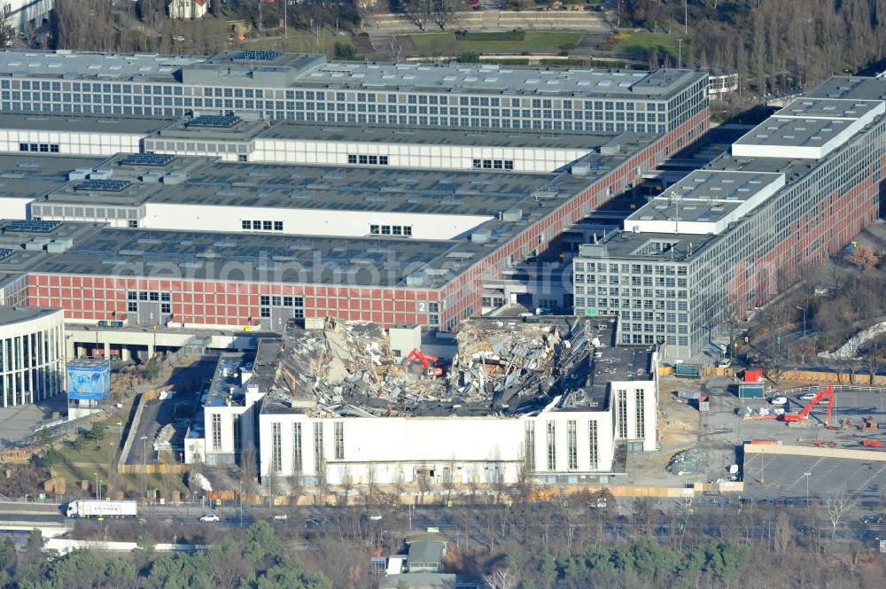 Aerial image Berlin - Blick auf die Abrißarbeiten an der ehemaligen Deutschlandhalle an der Jaffeystraße auf dem Messegelände in Charlottenburg. Abbruch-Bagger der Berliner Firma „ RWG1 “ setzten sie ihre tonnenschweren Kneifzangen in Betrieb und hackten sich in den Beton. Begonnen wurde mit dem Fassaden-Abriss an der Nordseite der Halle mit Abbruch-Bagger der Marke „ Liebherr “, Modelle 954 und 974. Sie wiegen 87 bis 140 Tonnen, haben bis zu 543 PS, nehmen die Fassade mit verschiedenen Greif- und Kneifbacken in die Zange. Der Abbruch soll bis März des Folgejahres beendet sein, um die nötige Baufreiheit für die Grundsteinlegung einer neuen Kongress- und Messehalle der Messe Berlin zu gewährleisten. Demolition work of the former Germany Halle Jaffeystraße on the fairgrounds in Charlottenburg.