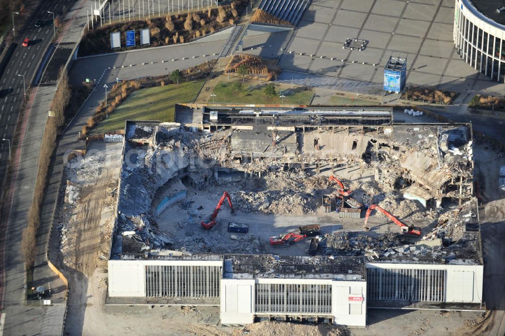 Aerial photograph Berlin - Blick auf die Abrißarbeiten an der ehemaligen Deutschlandhalle an der Jaffeystraße auf dem Messegelände in Charlottenburg. Abbruch-Bagger der Berliner Firma „ RWG1 “ setzten sie ihre tonnenschweren Kneifzangen in Betrieb und hackten sich in den Beton. Begonnen wurde mit dem Fassaden-Abriss an der Nordseite der Halle mit Abbruch-Bagger der Marke „ Liebherr “, Modelle 954 und 974. Sie wiegen 87 bis 140 Tonnen, haben bis zu 543 PS, nehmen die Fassade mit verschiedenen Greif- und Kneifbacken in die Zange. Der Abbruch soll bis März des Folgejahres beendet sein, um die nötige Baufreiheit für die Grundsteinlegung einer neuen Kongress- und Messehalle der Messe Berlin zu gewährleisten. Demolition work of the former Germany Halle Jaffeystraße on the fairgrounds in Charlottenburg.