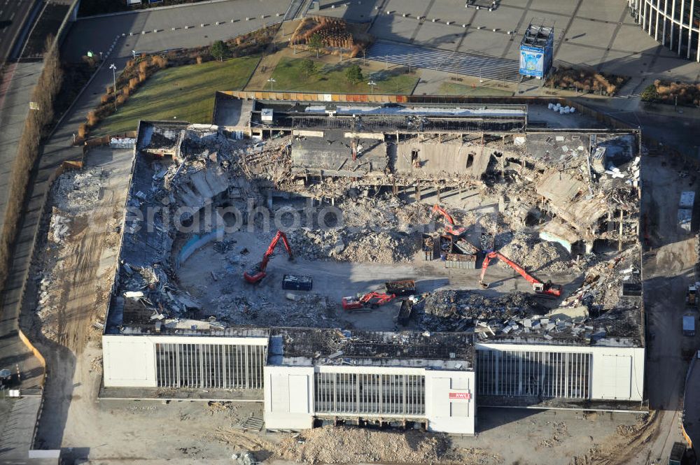 Berlin from above - Blick auf die Abrißarbeiten an der ehemaligen Deutschlandhalle an der Jaffeystraße auf dem Messegelände in Charlottenburg. Abbruch-Bagger der Berliner Firma „ RWG1 “ setzten sie ihre tonnenschweren Kneifzangen in Betrieb und hackten sich in den Beton. Begonnen wurde mit dem Fassaden-Abriss an der Nordseite der Halle mit Abbruch-Bagger der Marke „ Liebherr “, Modelle 954 und 974. Sie wiegen 87 bis 140 Tonnen, haben bis zu 543 PS, nehmen die Fassade mit verschiedenen Greif- und Kneifbacken in die Zange. Der Abbruch soll bis März des Folgejahres beendet sein, um die nötige Baufreiheit für die Grundsteinlegung einer neuen Kongress- und Messehalle der Messe Berlin zu gewährleisten. Demolition work of the former Germany Halle Jaffeystraße on the fairgrounds in Charlottenburg.