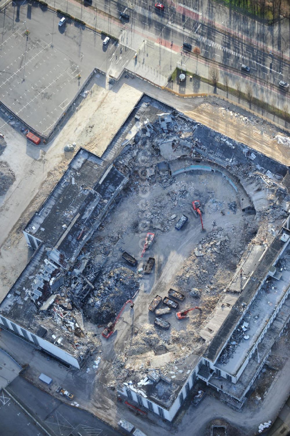 Aerial image Berlin - Blick auf die Abrißarbeiten an der ehemaligen Deutschlandhalle an der Jaffeystraße auf dem Messegelände in Charlottenburg. Abbruch-Bagger der Berliner Firma „ RWG1 “ setzten sie ihre tonnenschweren Kneifzangen in Betrieb und hackten sich in den Beton. Begonnen wurde mit dem Fassaden-Abriss an der Nordseite der Halle mit Abbruch-Bagger der Marke „ Liebherr “, Modelle 954 und 974. Sie wiegen 87 bis 140 Tonnen, haben bis zu 543 PS, nehmen die Fassade mit verschiedenen Greif- und Kneifbacken in die Zange. Der Abbruch soll bis März des Folgejahres beendet sein, um die nötige Baufreiheit für die Grundsteinlegung einer neuen Kongress- und Messehalle der Messe Berlin zu gewährleisten. Demolition work of the former Germany Halle Jaffeystraße on the fairgrounds in Charlottenburg.